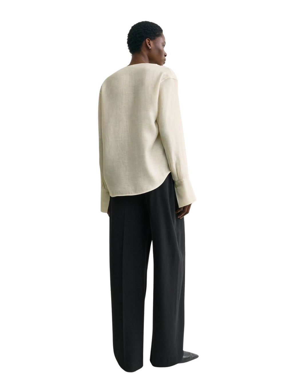 This TOTEME blouse combines refined craftsmanship with effortless style. Crafted from a luxurious blended wool in an elegant ecru shade, its oversized silhouette ensures comfort while maintaining a modern edge. The draped cowl neck creates a sophisticated focal point, complemented by long sleeves finished with buttoned cuffs for a polished look. The curved hem adds subtle fluidity, making this blouse a versatile piece that elevates both casual and formal ensembles with understated elegance.