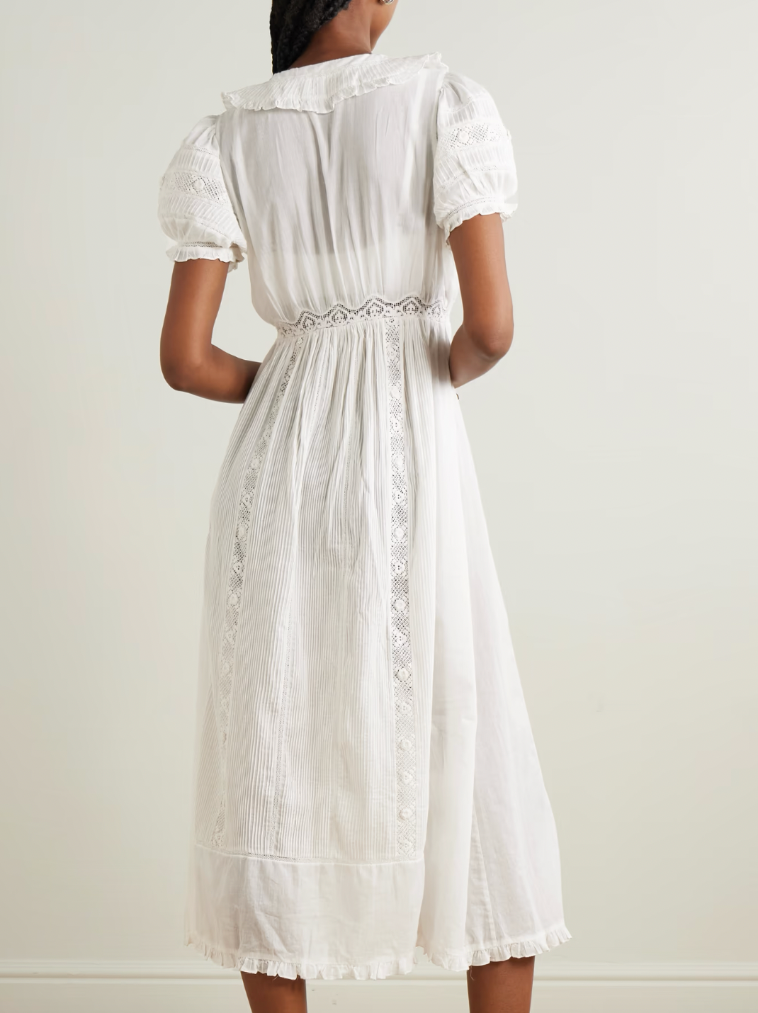 The Phoebe cotton-voile midi dress by DÔEN combines vintage charm with sustainable design. Crafted from organic cotton-voile, it features delicate lace trims and a classic Peter Pan collar. The dress gently cinches at the waist before flowing into a soft, floaty skirt, complemented by subtly puffed sleeves. This piece offers a refined, romantic silhouette ideal for those seeking timeless elegance with eco-conscious materials.