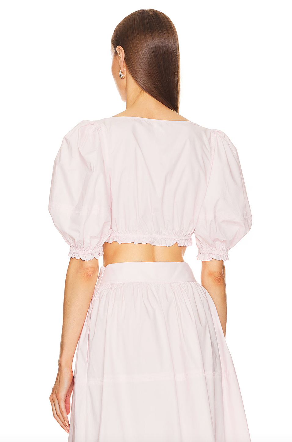 The Poplin Cropped Peasant Top by Helsa features airy puff sleeves with elastic cuffs for comfortable movement and a flattering silhouette. A delicate bow detail at the front adds a subtle touch of charm, while the elastic underband ensures a secure yet flexible fit. Crafted from lightweight poplin fabric, this top offers breathability and a crisp, polished appearance ideal for warm-weather styling.
