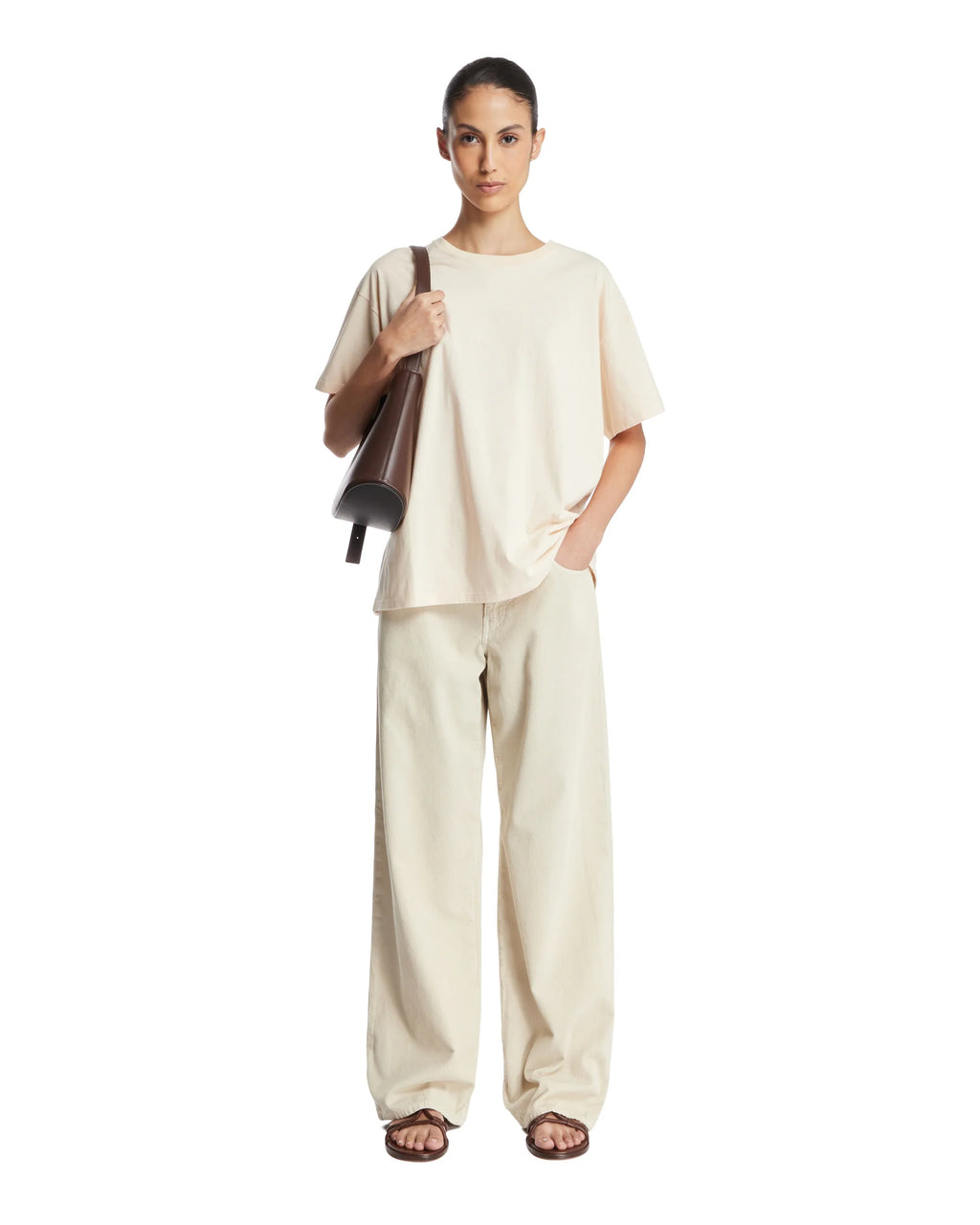 The Beige Nadina Oversized T-shirt from The Row combines effortless style and comfort. Crafted from soft beige cotton, it features a classic crew neckline, short sleeves, and a straight hem for a clean silhouette. Its oversized fit is thoughtfully enhanced with ribbed details, adding subtle texture and structure. This versatile piece offers a relaxed yet refined look, ideal for layering or wearing alone with ease.