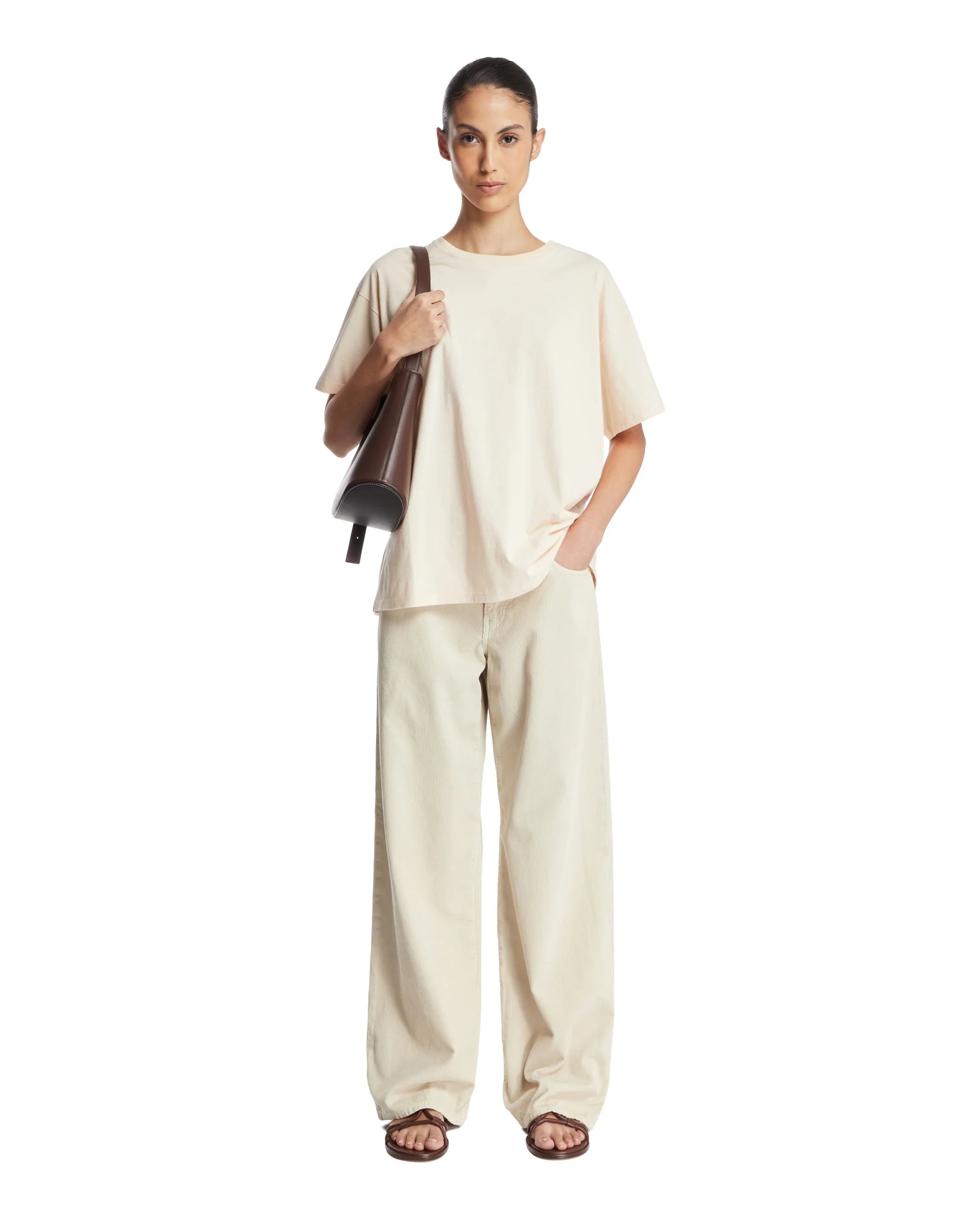 The Beige Nadina Oversized T-shirt from The Row combines effortless style and comfort. Crafted from soft beige cotton, it features a classic crew neckline, short sleeves, and a straight hem for a clean silhouette. Its oversized fit is thoughtfully enhanced with ribbed details, adding subtle texture and structure. This versatile piece offers a relaxed yet refined look, ideal for layering or wearing alone with ease.