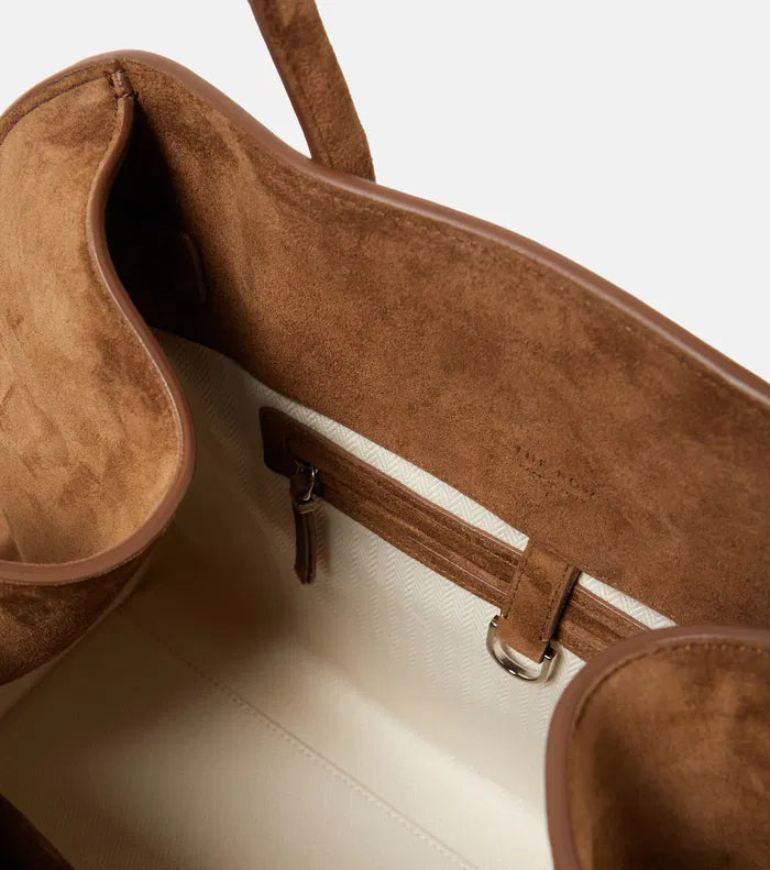 The Soft Margaux 15 Suede Tote Bag by The Row features a softly structured design crafted from supple calfskin suede, offering both elegance and durability. Its belted gusseted side panels provide a refined silhouette while allowing flexible storage capacity. Inside, the spacious interior is thoughtfully designed for organization, making it ideal for daily use with a sophisticated touch.