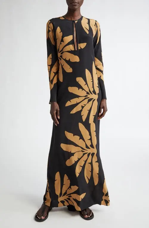 The Southwestern Long Sleeve Maxi Dress by Johanna Ortiz showcases a striking tropical frond pattern that captures a vibrant, nature-inspired aesthetic. Designed in a tunic silhouette, it features a daring chest cutout paired with a sophisticated jewel neckline, balancing boldness with elegance. The long sleeves provide added coverage, making it suitable for various occasions while maintaining a flowy, comfortable fit typical of maxi dresses. This piece blends artistic design with wearable sophistication, i