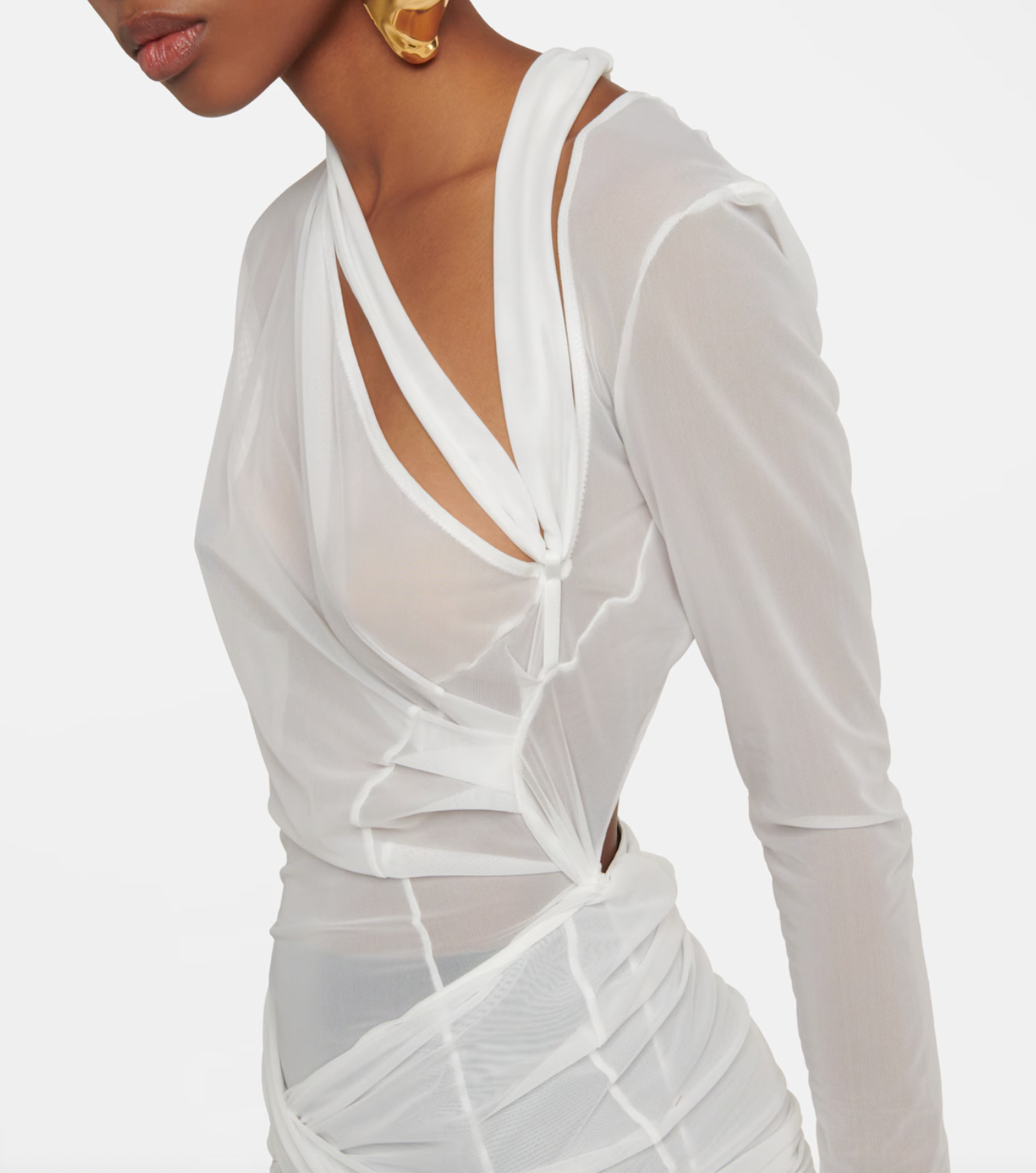 The La Robe Piombone tulle maxi dress by Jacquemus showcases a refined sheer tulle construction with a draped, full-length silhouette that elegantly contours the body. Its asymmetric neckline adds a modern architectural touch, while the long sleeves with thumb holes provide subtle coverage and a distinctive detail. The high-cut side slit enhances movement and introduces a sensual element, making this dress a sophisticated statement for formal occasions or avant-garde styling.