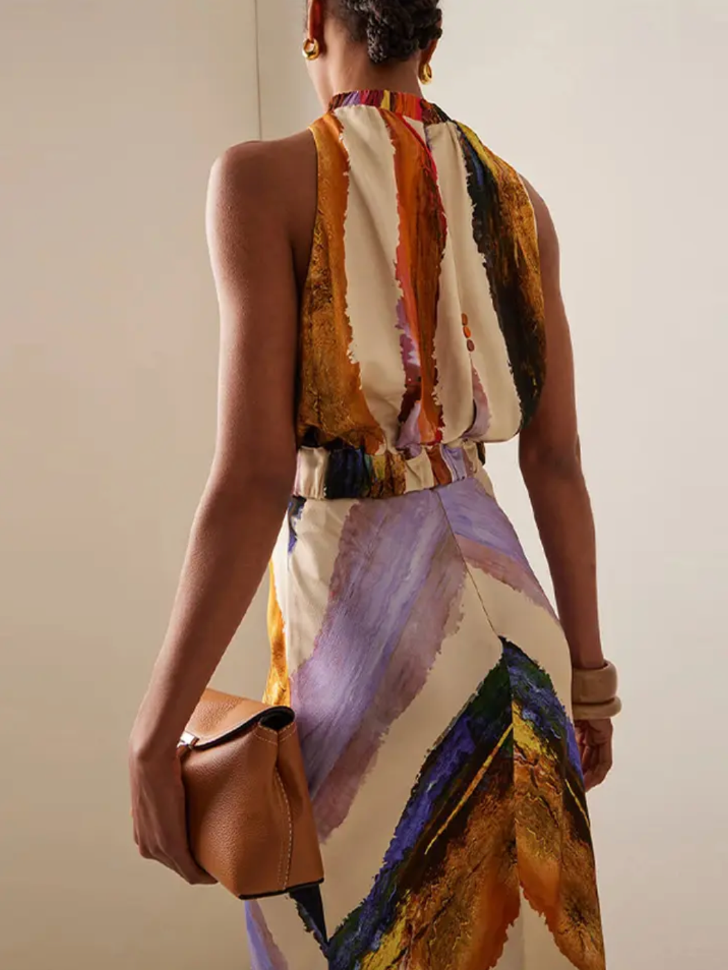 This standout set includes a sleeveless crop top with a halter design that leaves the back exposed, combined with a high-waisted maxi skirt with a modern print. The elongated skirt stylizes the figure, while the top provides a feeling of freshness and sophistication, perfect for summer occasions and casual events with an elegant touch. Its balance between comfort and trend makes this set an ideal choice for those looking for a contemporary and refined look.