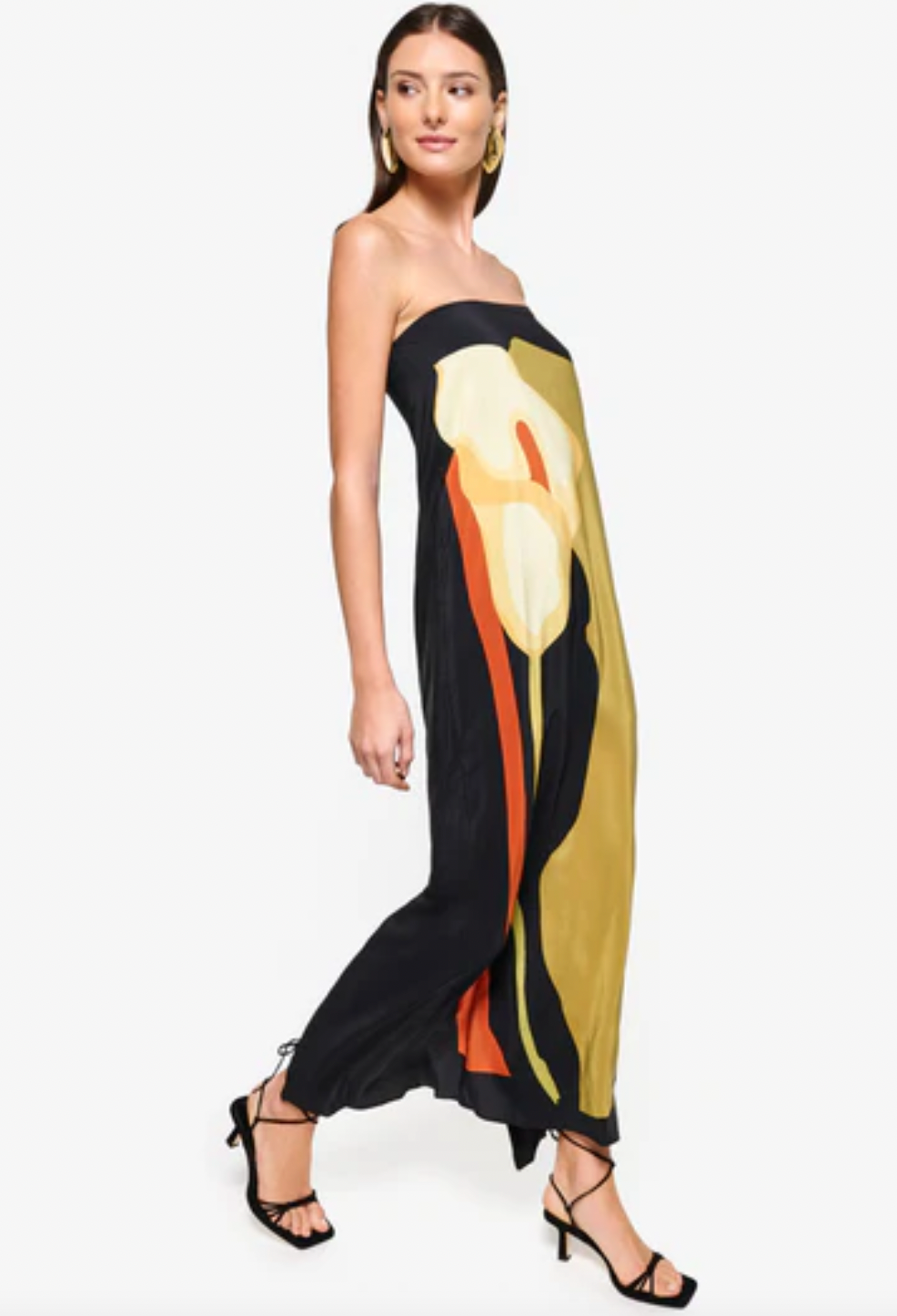 The Dalva Dress offers an elegant blend of sophistication and comfort with its strapless, column silhouette crafted from luxurious silk. Lined with the exclusive 'Calla' print, it provides both style and a smooth fit. The added elastic ensures secure support, while the back slit enhances mobility and adds a subtle allure. An invisible zipper completes the design for a flawless finish, making it an ideal choice for any refined occasion. Designed by Laura Cangussu in collaboration with Couper.