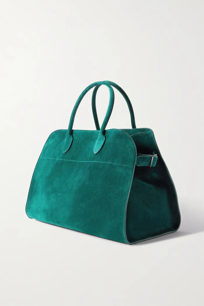 Crafted in Italy from smooth suede, the Margaux Air Suede Tote by The Row offers a softly structured silhouette enhanced by adjustable buckled sides for a customizable fit. Its thoughtful interior pockets provide secure storage for your essentials, merging elegant design with practical functionality. Made from 100% leather, this tote combines refined craftsmanship with everyday utility.