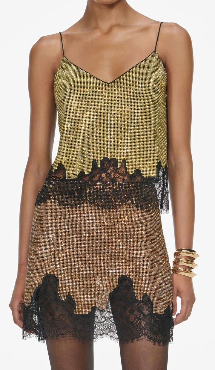 Elevate your party wardrobe with the Champagne Crystal Top, designed for confident, stylish wear. This relaxed-fit top features sparkling champagne crystals and delicate lace trims at the hem, adding a refined boudoir touch. Fully lined for comfort and finished with a button closure at the back, it pairs effortlessly with matching skirts and heels for a standout look that lasts all night. 