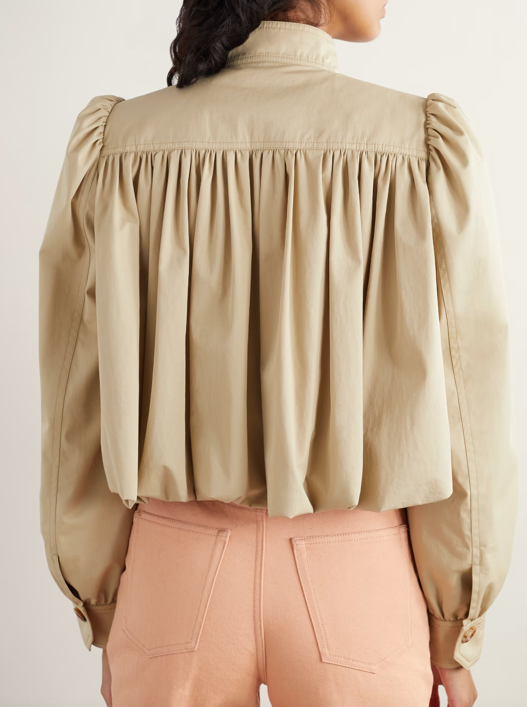 Chloé’s gathered cotton-twill jacket features a distinctive bubble hem and delicate gathers at the yoke and shoulders, offering a structured yet softly voluminous silhouette. Crafted from breathable cotton twill, it balances comfort with sophisticated tailoring. Ideal for layering, pair it with high-rise jeans and layered jewelry to channel the refined ease of the Spring ’25 runway. This jacket merges modern design with timeless wearability for a standout, expert-level addition to your wardrobe.