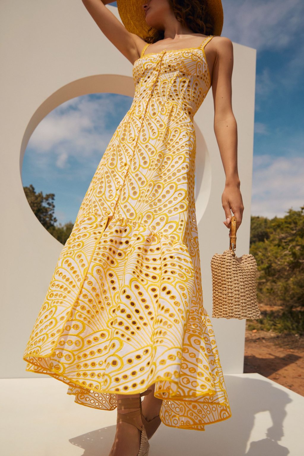 The Irene Dress by Charo Ruiz Ibiza features a front button design that allows for a full opening, enhancing ease and elegance. Crafted from partially lined embroidered batiste, it boasts a corseted bodice with a Balconette neckline that sculpts the silhouette. The dress culminates in a striking skirt, flowing into a dramatic ruffle made from the same delicate openwork fabric, combining structure with a graceful, airy finish.
