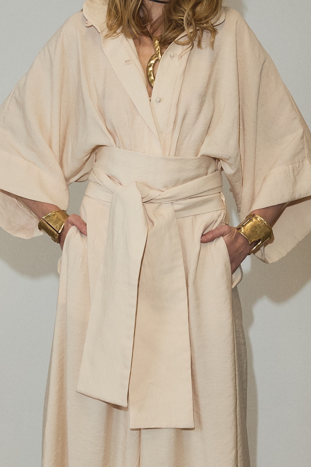 The Lauren Jumpsuit embodies refined sophistication with its architectural kimono sleeves and tailored waist, creating a striking wide-leg silhouette that merges bold design with effortless movement. Made from a breathable viscose blend, it offers a soft, flowing drape complemented by a sharp collar and a sculptural belt that defines the waist. This versatile piece transitions seamlessly from relaxed mornings to commanding appearances, reflecting timeless style and expert craftsmanship.