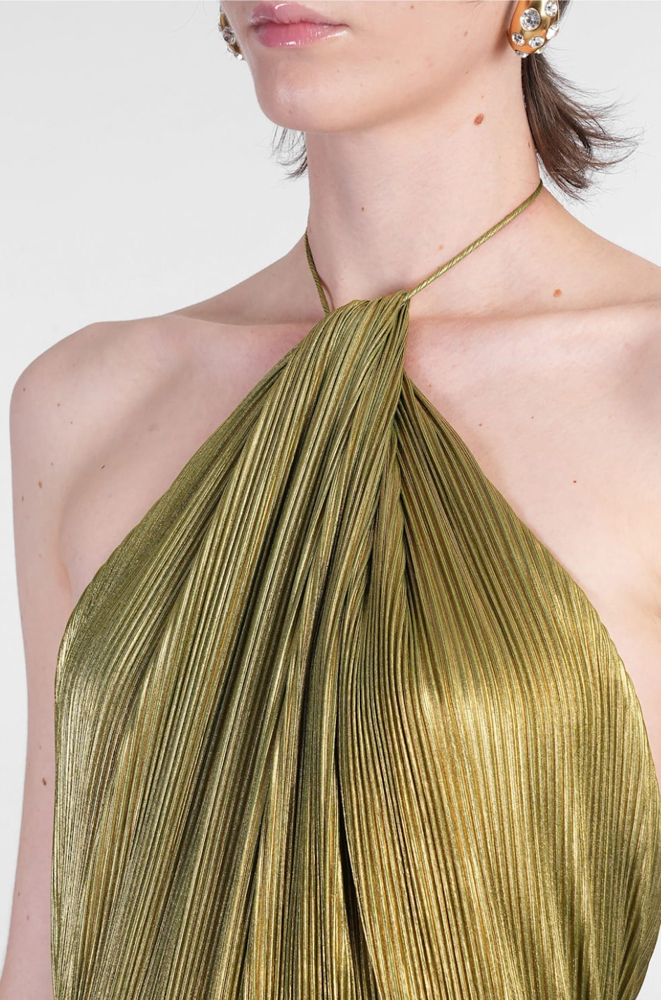 The Thalia Dress by Retrofete showcases pleated satin that shimmers with every movement. Its halterneck tie-up closure and concealed back zipper deliver a tailored fit, complemented by an open back that exudes refined allure. Partially lined for comfort and featuring a front slit, this dress balances elegance with ease of wear, making it a sophisticated choice for any upscale event.