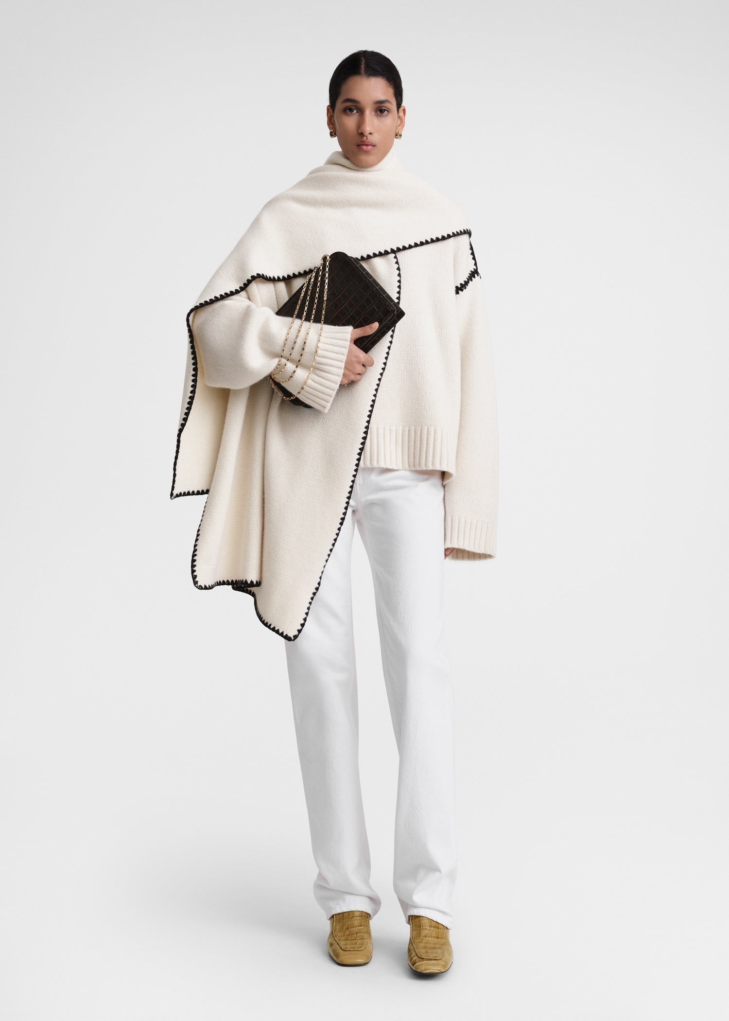 This wide sweater channels the refined aesthetic of TOTEME's Embroidered Scarf Jacket, crafted from mid-weight wool blended with cashmere for superior warmth and softness. Detailed with contrasting thread embroidery along the shoulders and armholes, it adds a sophisticated artisanal touch to classic knitwear. Pair it with the matching scarf to create a cohesive, statement winter ensemble that combines comfort with expert craftsmanship.