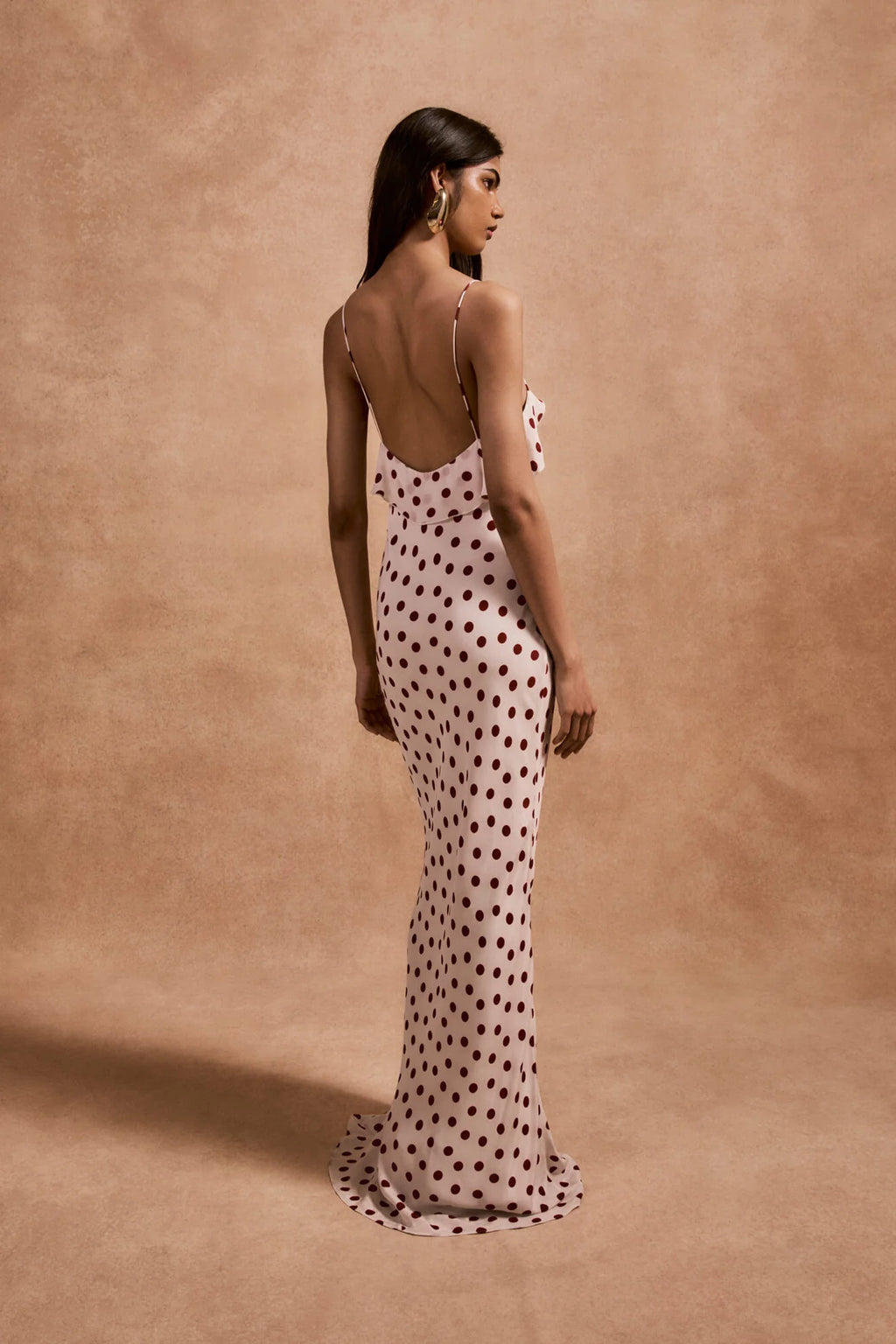 The Esperanza Long Dress by De La Vali combines expert craftsmanship with timeless elegance. Made from 100% viscose crepe de chine, its bias-cut silhouette drapes gracefully, enhanced by an ivory and red polka dot pattern. The ruffled bust adds a refined detail that elevates the dress’s charm. Perfect for formal events or stylish evenings, it pairs beautifully with strappy sandals and delicate jewelry to create a sophisticated, polished look.