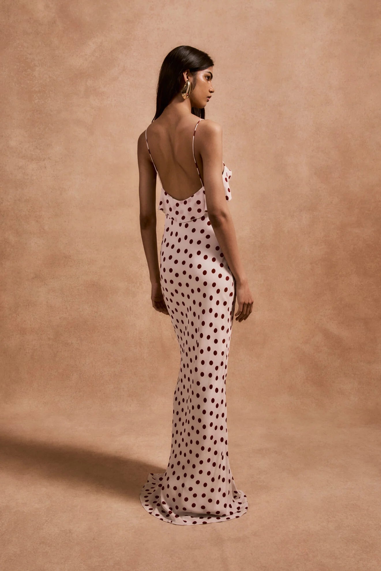 The Esperanza Long Dress by De La Vali combines expert craftsmanship with timeless elegance. Made from 100% viscose crepe de chine, its bias-cut silhouette drapes gracefully, enhanced by an ivory and red polka dot pattern. The ruffled bust adds a refined detail that elevates the dress’s charm. Perfect for formal events or stylish evenings, it pairs beautifully with strappy sandals and delicate jewelry to create a sophisticated, polished look.