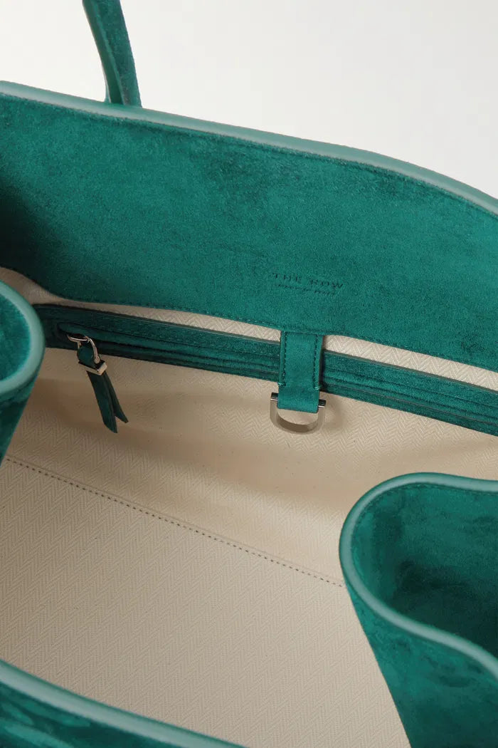 Crafted in Italy from smooth suede, the Margaux Air Suede Tote by The Row offers a softly structured silhouette enhanced by adjustable buckled sides for a customizable fit. Its thoughtful interior pockets provide secure storage for your essentials, merging elegant design with practical functionality. Made from 100% leather, this tote combines refined craftsmanship with everyday utility.