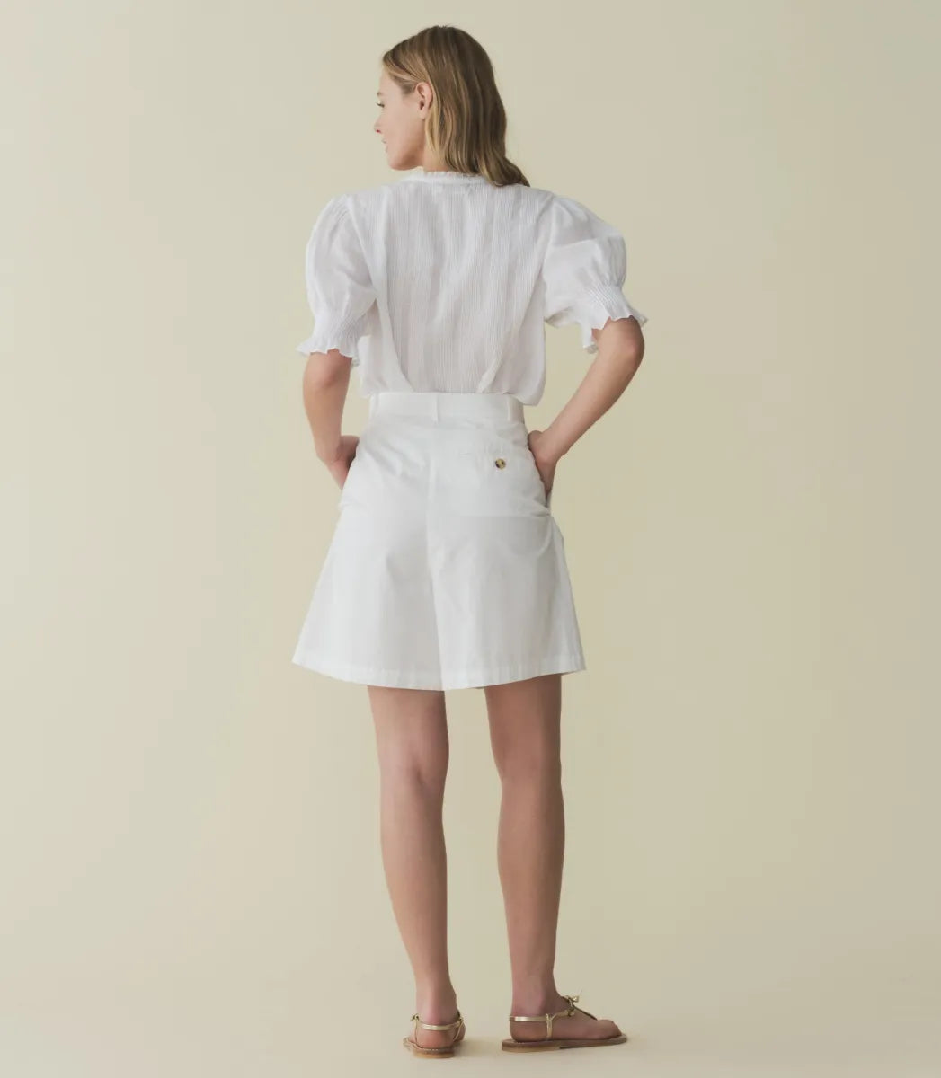 The Karlie Top by Doen is expertly crafted from lightweight ramie, offering a sheer, airy feel. Its Edwardian-inspired silhouette features a plunging V-neckline trimmed with delicate ruffles and intricate pintuck detailing along the yoke, back, and puffed sleeves. A central button line allows versatile styling, whether worn loosely or tucked in, making it an ideal match for high-waisted jeans. This top seamlessly blends timeless romantic details with contemporary functionality.