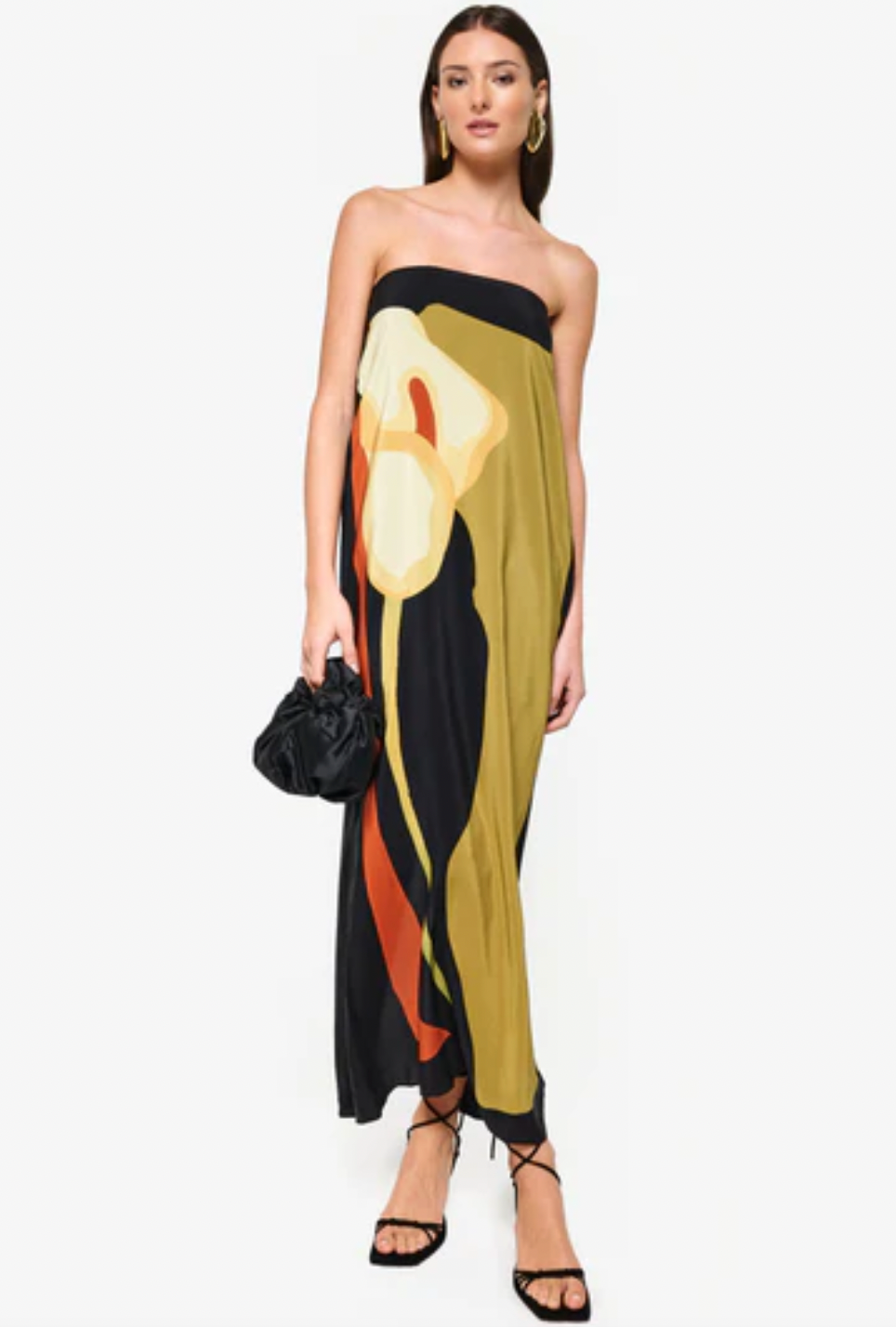 The Dalva Dress offers an elegant blend of sophistication and comfort with its strapless, column silhouette crafted from luxurious silk. Lined with the exclusive 'Calla' print, it provides both style and a smooth fit. The added elastic ensures secure support, while the back slit enhances mobility and adds a subtle allure. An invisible zipper completes the design for a flawless finish, making it an ideal choice for any refined occasion. Designed by Laura Cangussu in collaboration with Couper.