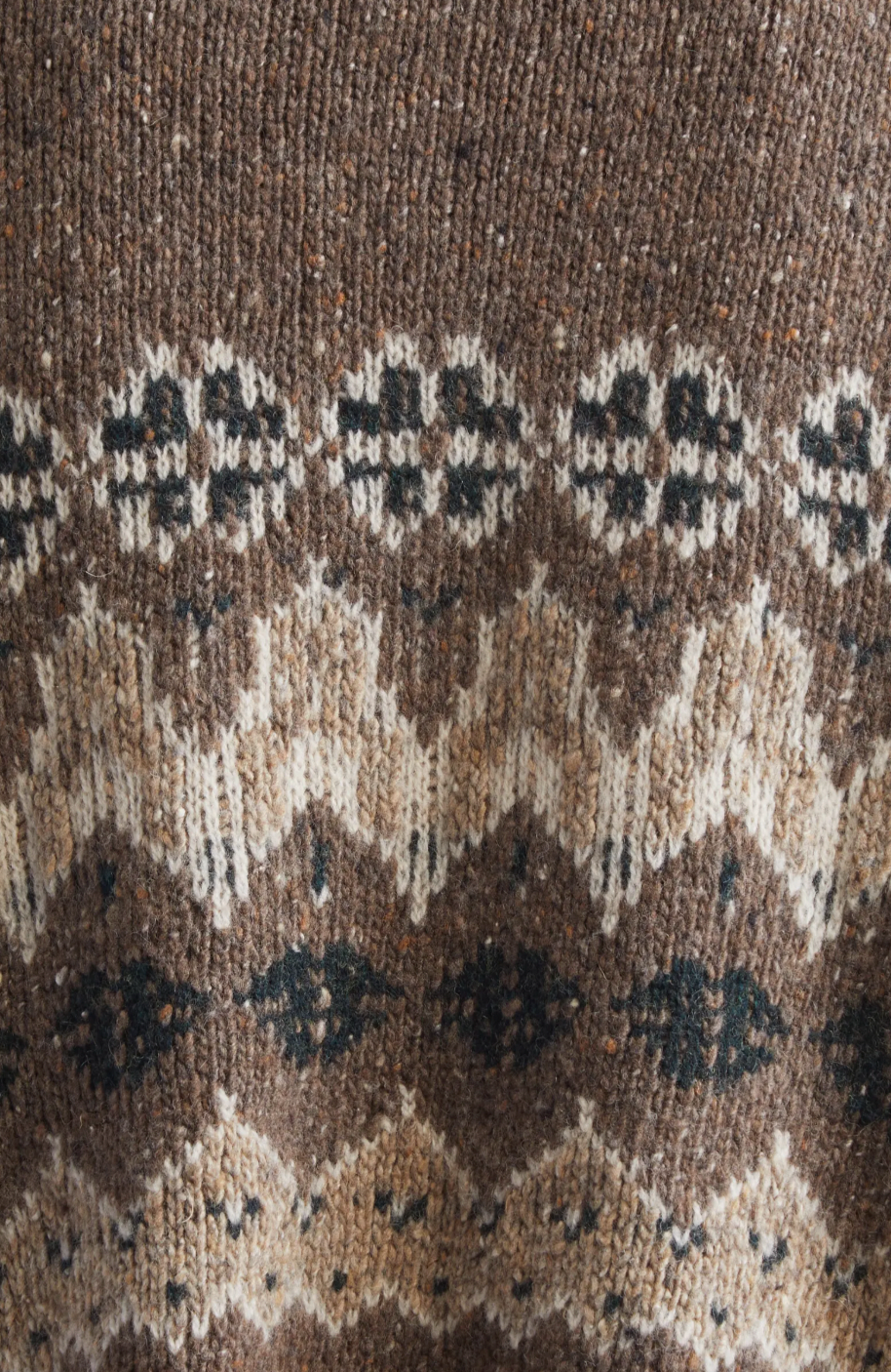 This sophisticated cardigan reimagines classic Fair Isle aesthetics through a contemporary lens, crafted from a textured wool blend that delivers both visual interest and warmth. The dropped-shoulder silhouette creates an effortlessly relaxed fit, while the traditional motif patterns add timeless appeal to your everyday rotation. 