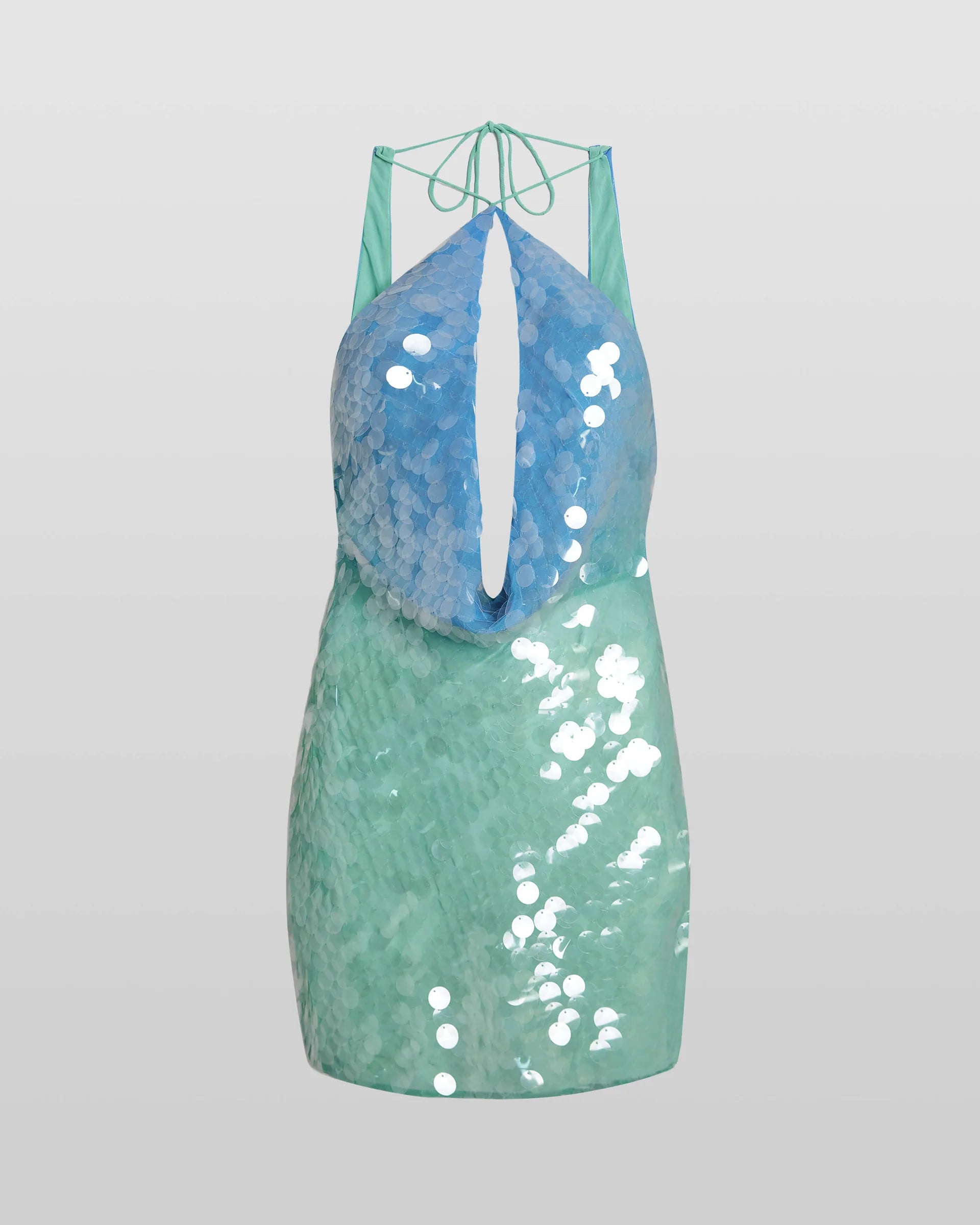 The Kiki Dress captivates with its molten sequin ombré, flowing seamlessly from blue to green for a striking summer soirée look. Expertly bias-cut, it contours the body with a flattering drape that highlights the luxe fabric’s fluidity. Featuring a sensual plunging back and dramatic cowl neckline, this dress embodies refined elegance and vibrant energy, perfect for making a lasting impression on warm, lively nights.