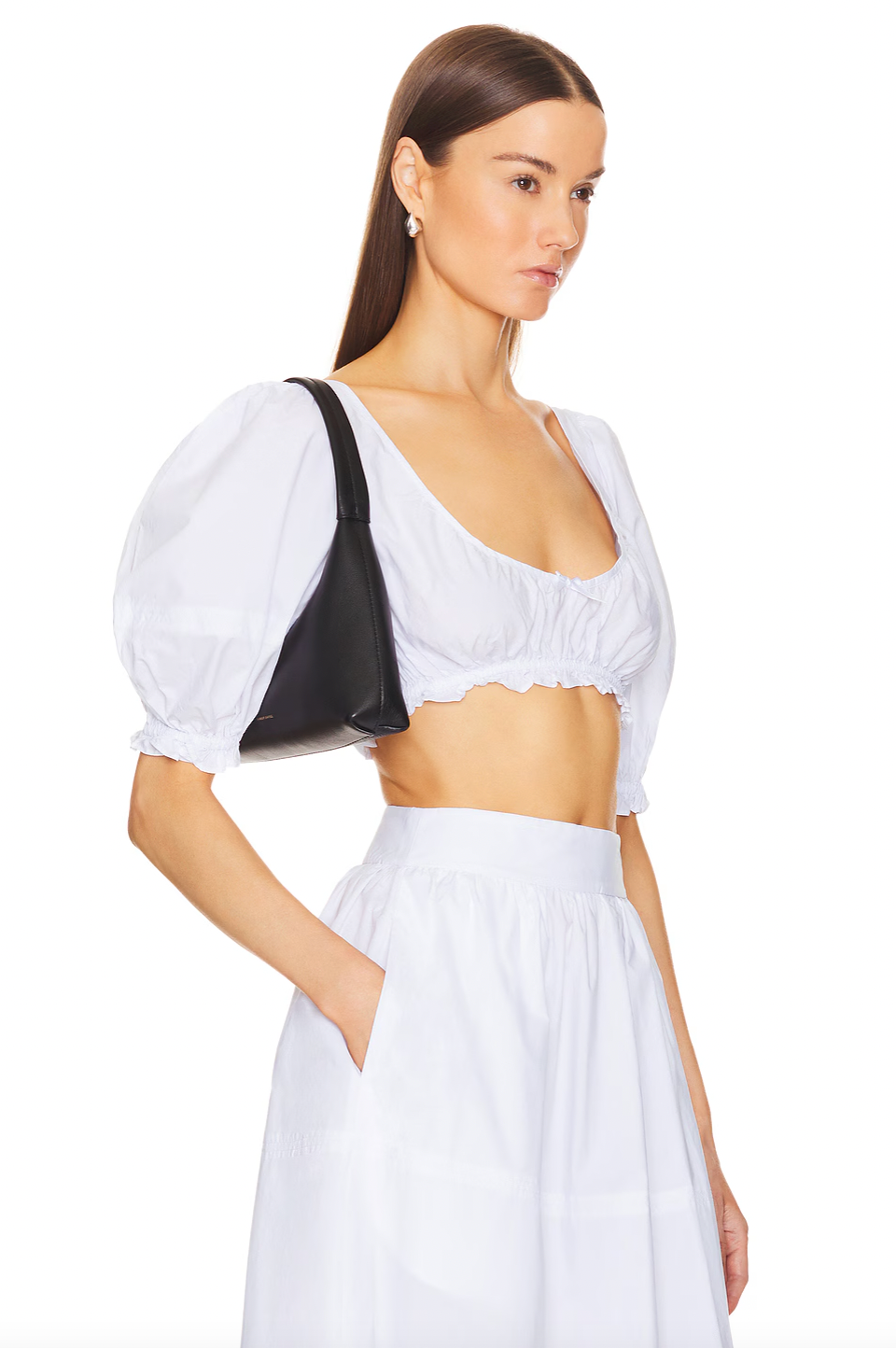 The Poplin Cropped Peasant Top by Helsa features airy puff sleeves with elastic cuffs for comfortable movement and a flattering silhouette. A delicate bow detail at the front adds a subtle touch of charm, while the elastic underband ensures a secure yet flexible fit. Crafted from lightweight poplin fabric, this top offers breathability and a crisp, polished appearance ideal for warm-weather styling.