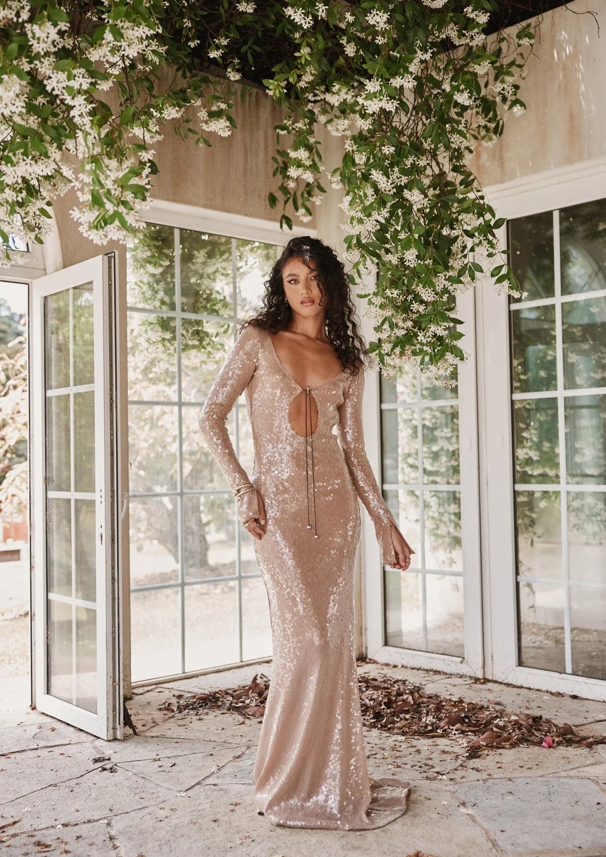 The Solaris Gown in Smoke Sequin showcases a sophisticated keyhole cutout neckline with adjustable drawstring closures at both front and back for a customized fit. Designed with extended sleeves, its slim-fit silhouette includes slight stretch for comfort and ease of movement. The gown slips on effortlessly over the head and is layered with a soft-touch slip to ensure a smooth, itch-free wear experience. Perfect for elegant occasions, it balances striking design with comfort and refined craftsmanship.