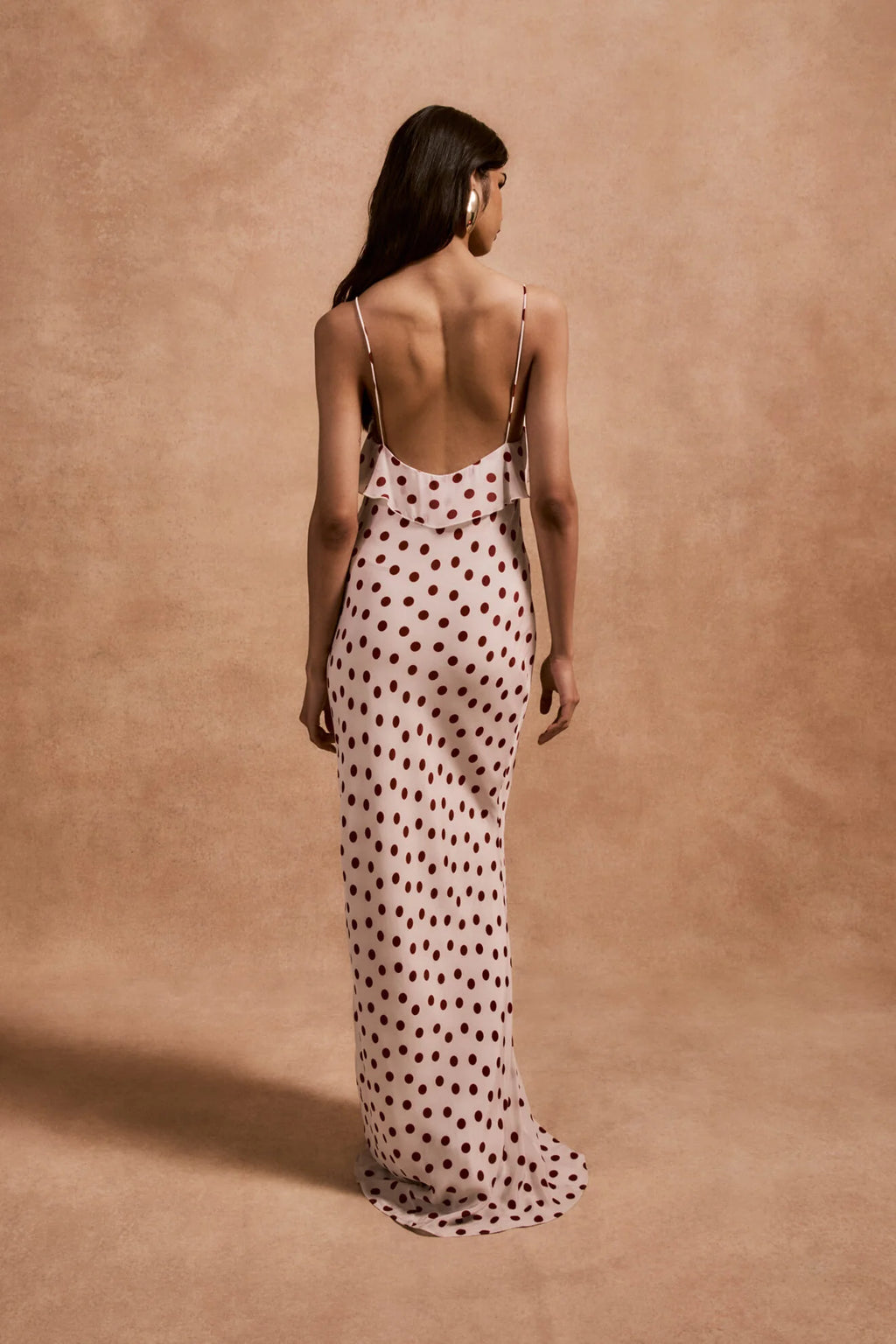 The Esperanza Long Dress by De La Vali combines expert craftsmanship with timeless elegance. Made from 100% viscose crepe de chine, its bias-cut silhouette drapes gracefully, enhanced by an ivory and red polka dot pattern. The ruffled bust adds a refined detail that elevates the dress’s charm. Perfect for formal events or stylish evenings, it pairs beautifully with strappy sandals and delicate jewelry to create a sophisticated, polished look.