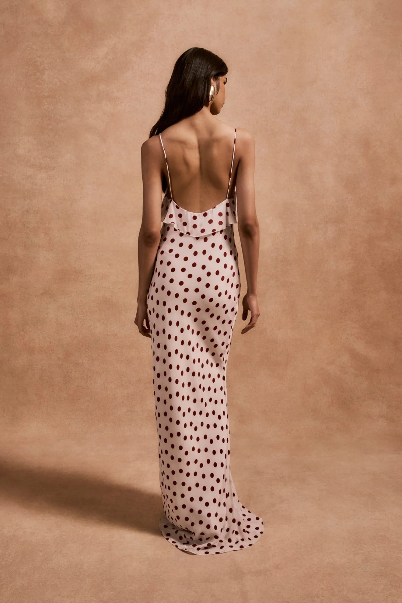 The Esperanza Long Dress by De La Vali combines expert craftsmanship with timeless elegance. Made from 100% viscose crepe de chine, its bias-cut silhouette drapes gracefully, enhanced by an ivory and red polka dot pattern. The ruffled bust adds a refined detail that elevates the dress’s charm. Perfect for formal events or stylish evenings, it pairs beautifully with strappy sandals and delicate jewelry to create a sophisticated, polished look.