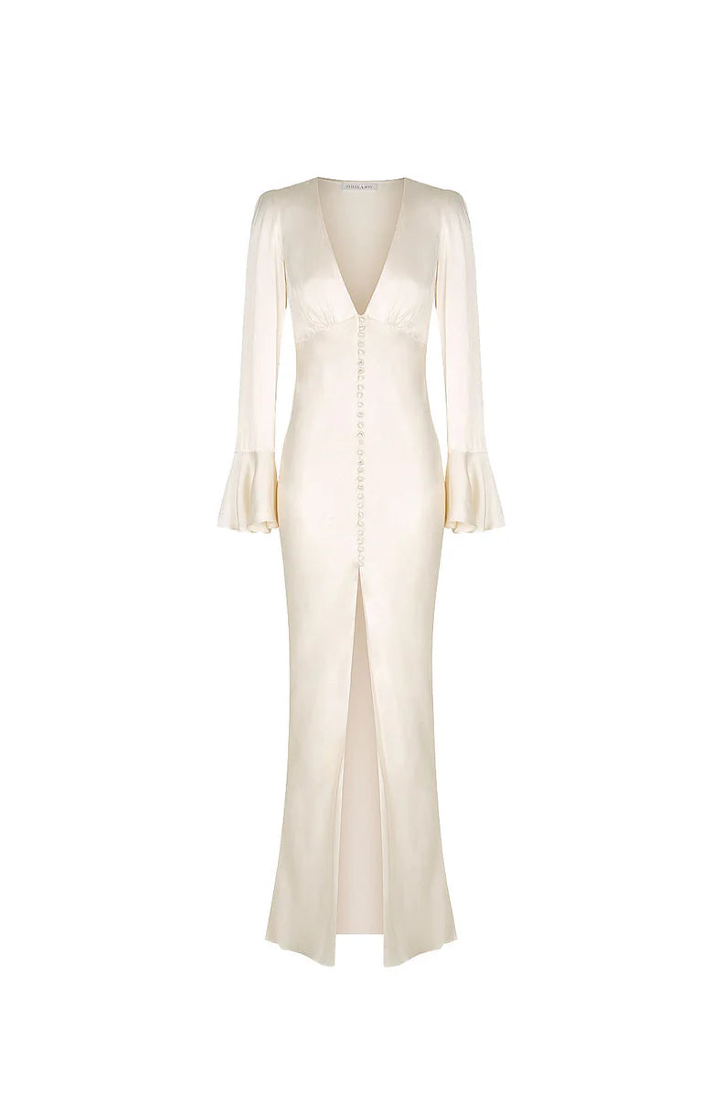The La Lune Frill Midi Dress blends Victorian-inspired elegance with contemporary design. Crafted from silk-touch fabric in a creamy hue, it offers a luxurious sheen and a flattering slim fit. Key features include a plunging neckline, gathered bust detail, and decorative front button tab for a lengthening effect. The slim sleeves end in graceful frill cuffs, while an invisible side zip ensures a seamless silhouette. The midi skirt, finished with a front hem split, combines sophistication with subtle allure,