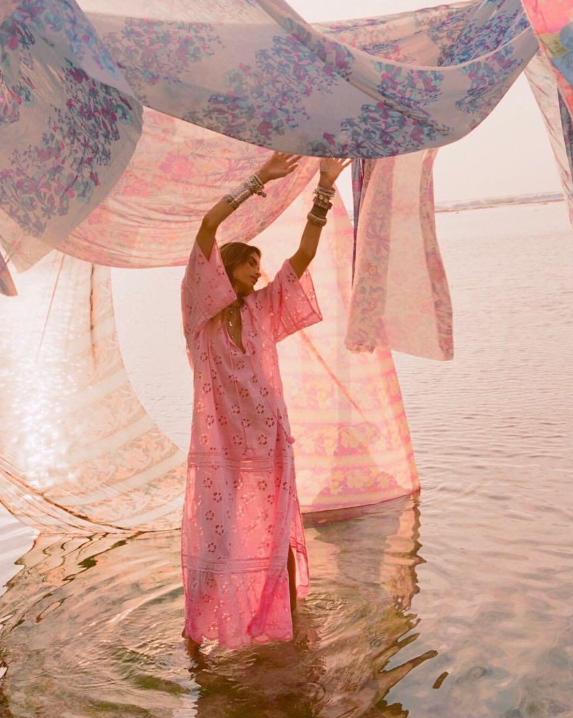 Step into a daydream with the Love Note Broderie Gown in Cosmos Pink, a gown that speaks of romance and delicate femininity. The soft pink hue, combined with custom embroidery and lace, lends an air of whimsy and beauty. A V-neckline with a keyhole opening at the centre front and side splits create a graceful, flowing silhouette, while flutter sleeves add a touch of fairytale magic. 
