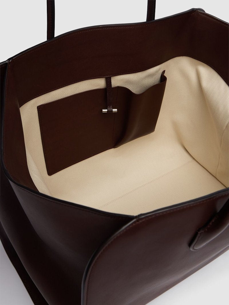 Crafted in Italy from 100% calf leather, the Marlo 17 Saddle Leather Tote Bag combines refined craftsmanship with practical design. Its chestnut hue complements double top handles for comfortable carrying, while a top toggle closure ensures secure access. The tote is lined and features an internal pocket to organize essentials, making it a sophisticated yet functional everyday accessory.