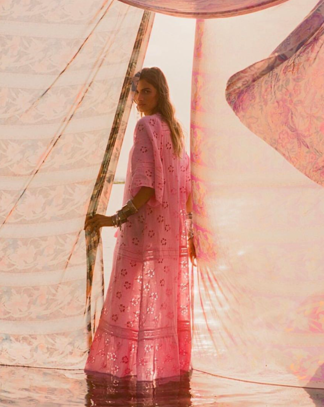 Step into a daydream with the Love Note Broderie Gown in Cosmos Pink, a gown that speaks of romance and delicate femininity. The soft pink hue, combined with custom embroidery and lace, lends an air of whimsy and beauty. A V-neckline with a keyhole opening at the centre front and side splits create a graceful, flowing silhouette, while flutter sleeves add a touch of fairytale magic. 