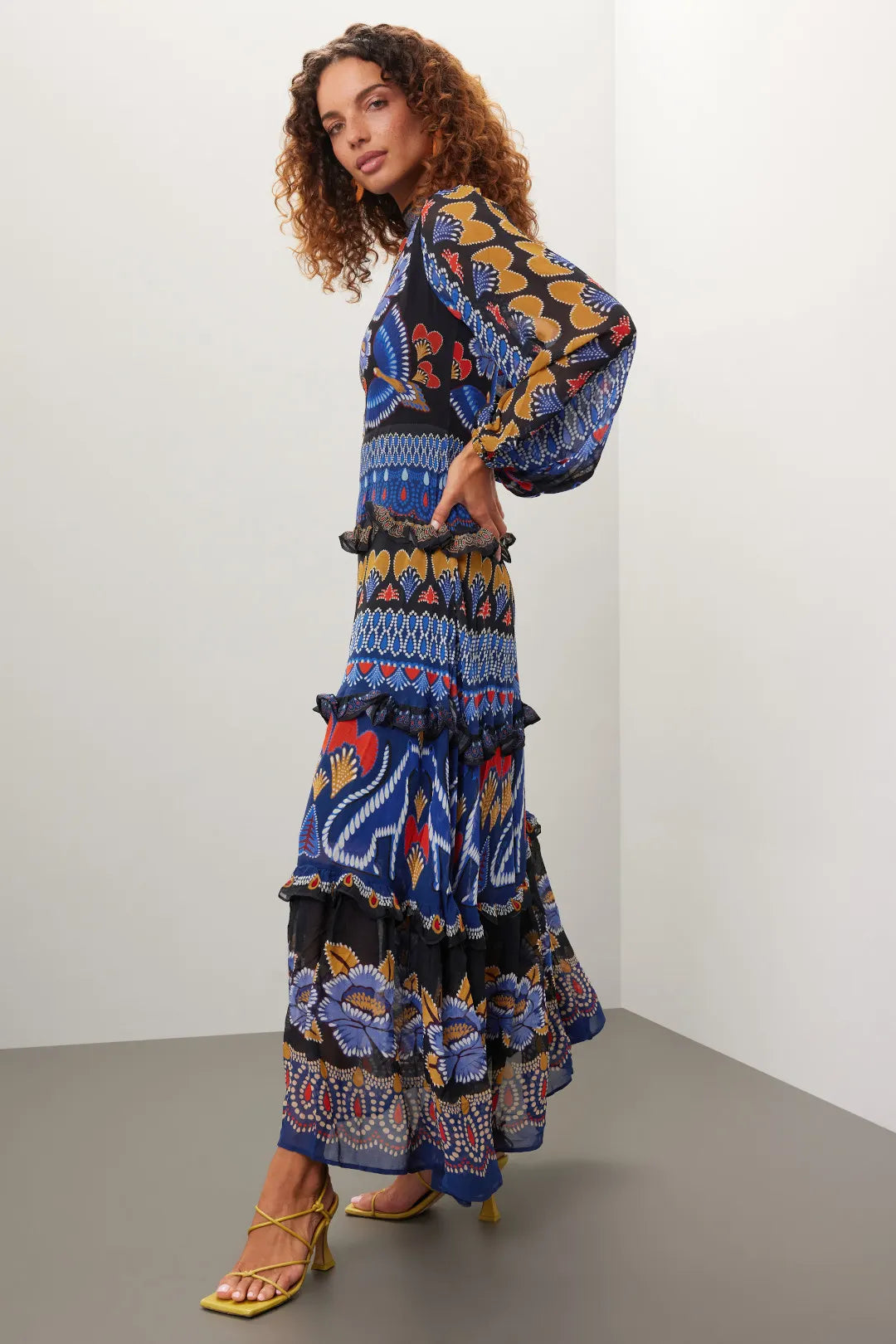 Brighten up fall with the Anika Maxi Dress from FARM Rio, featuring colorful contrasting prints and a charming ruffle trim. Made from lightweight black geometric print chiffon, this A-line dress flows elegantly with long sleeves and a stylish mock neck. The back zipper ensures a perfect fit, while the 56-inch length creates a dramatic silhouette. Perfect for those who want to capture summer's vibrant spirit all season long.