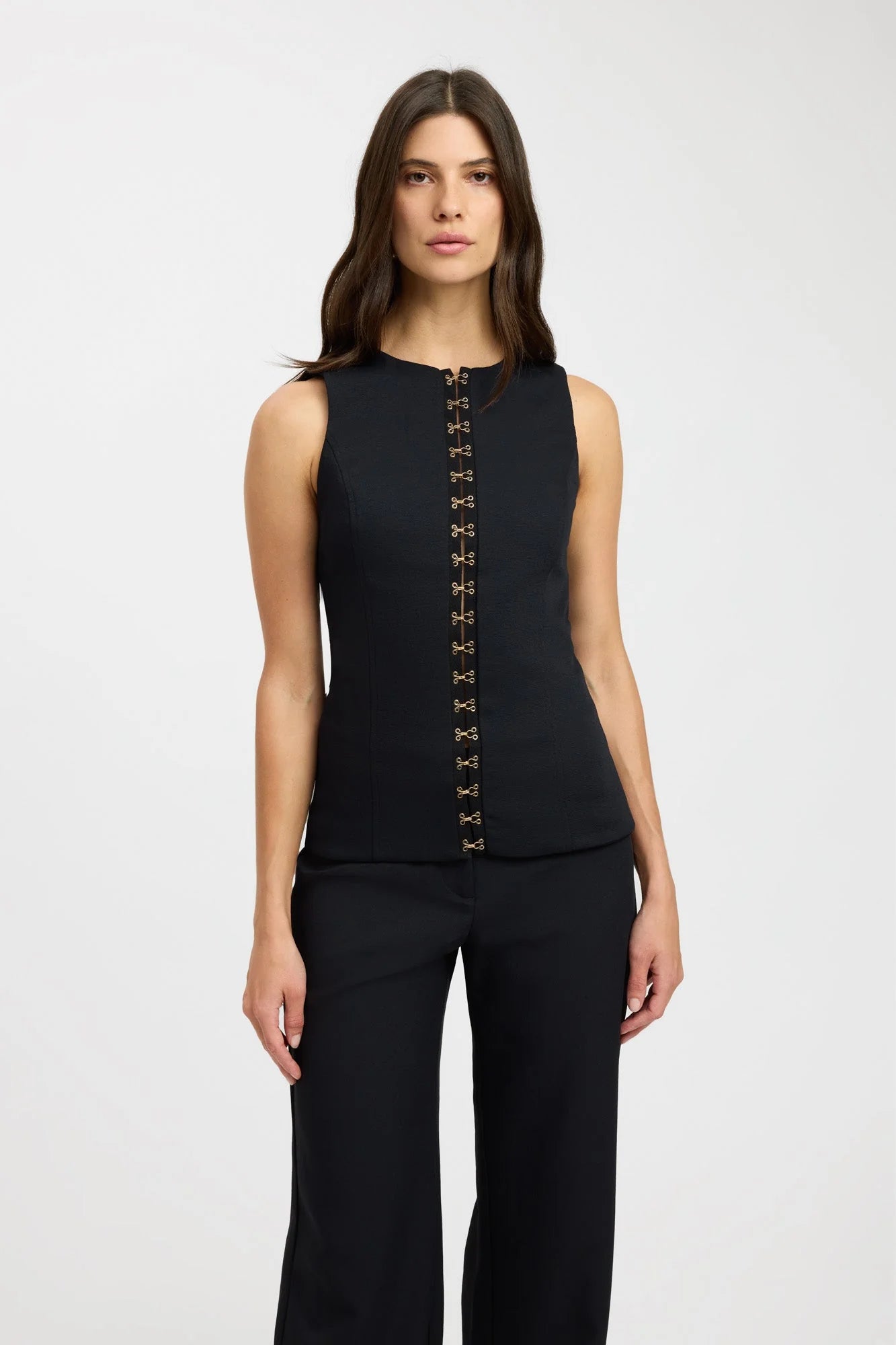 Elevate your fashion game with the Oyster Hook Crew Top in Black. Made from luxurious suiting fabric, this top boasts a sophisticated high neckline and flattering flared hemline. The adjustable gold hook and eye details add a touch of elegance and allow for customizable styling. Make a statement with this must-have piece.