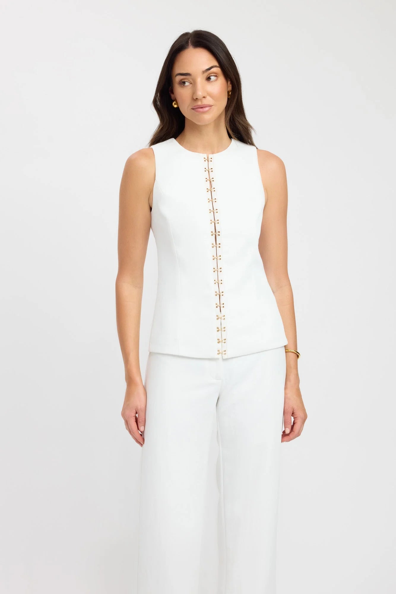 Introducing the Oyster Hook Crew Top, designed to make a statement. Crafted from suiting fabrication. The silhouette features an elegant high neckline and subtly flared hemline. Along with gold hook and eye details that can be adjusted for self styling.