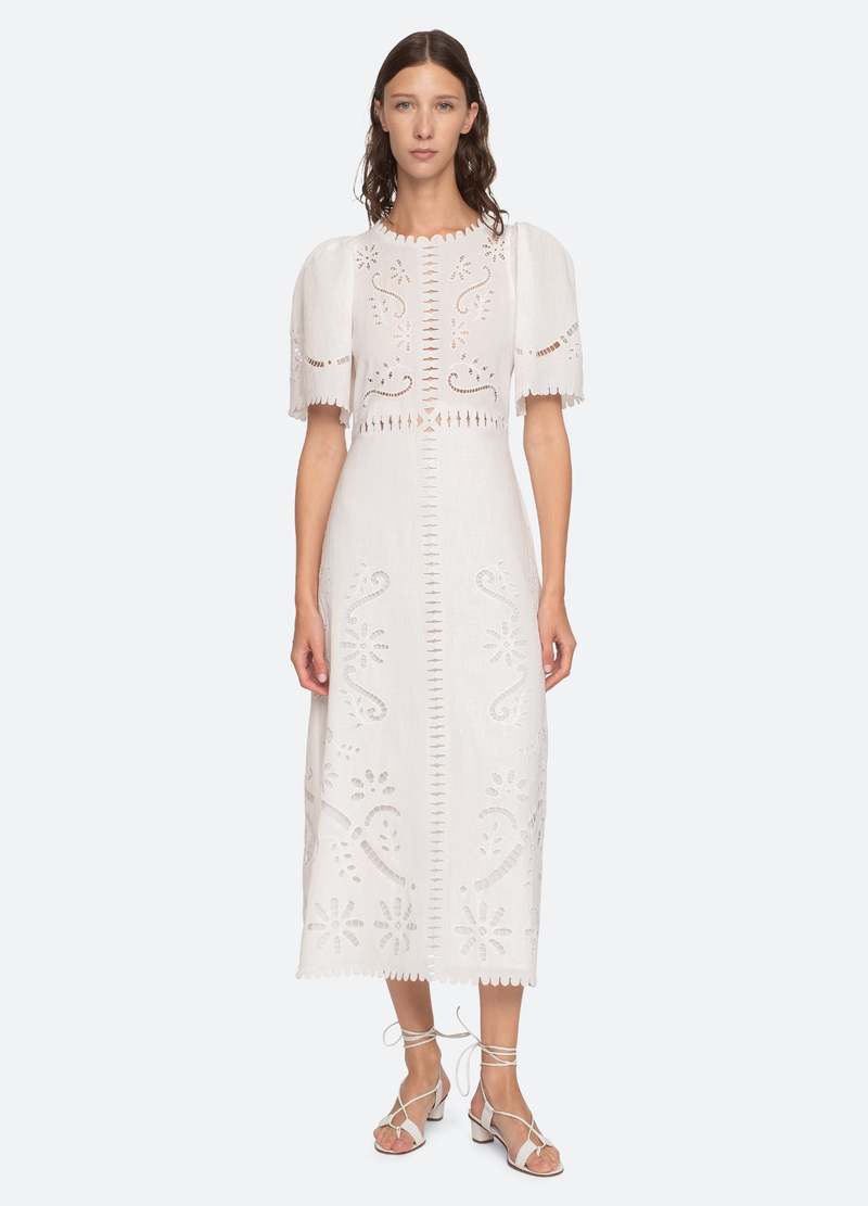The Liat Dress by Sea New York combines delicate eyelet floral embroidery with thoughtful cutout accents and refined scalloped trim, offering a sophisticated touch to your wardrobe. Its short sleeves and intricate detailing create an elegant yet breathable design, perfect for warm weather occasions where effortless style and comfort are essential.
