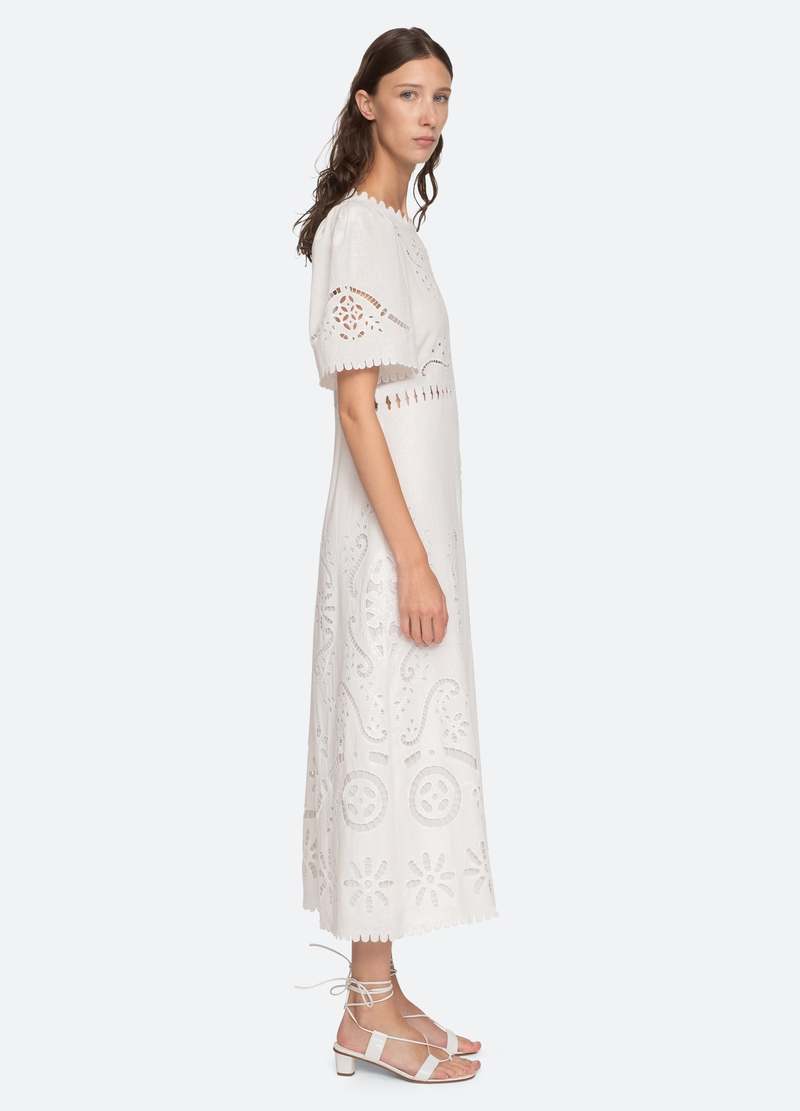 The Liat Dress by Sea New York combines delicate eyelet floral embroidery with thoughtful cutout accents and refined scalloped trim, offering a sophisticated touch to your wardrobe. Its short sleeves and intricate detailing create an elegant yet breathable design, perfect for warm weather occasions where effortless style and comfort are essential.