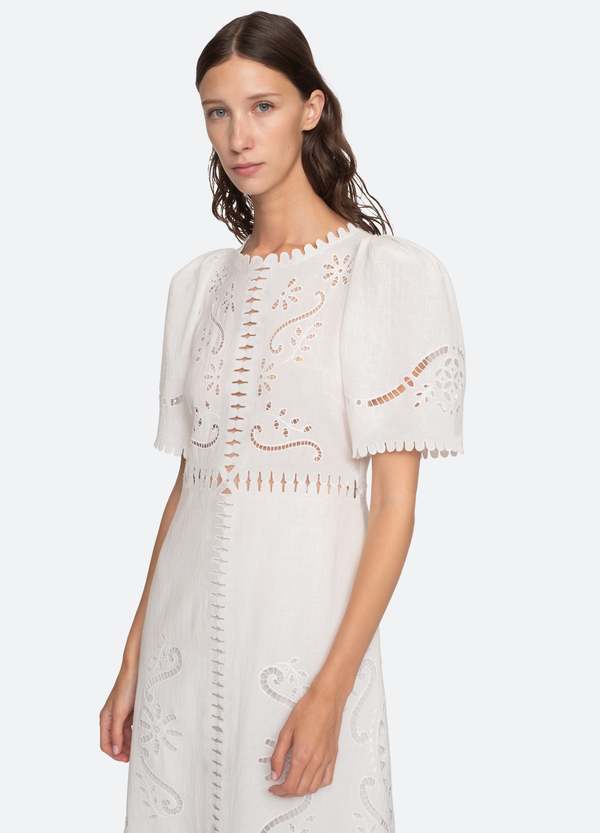 The Liat Dress by Sea New York combines delicate eyelet floral embroidery with thoughtful cutout accents and refined scalloped trim, offering a sophisticated touch to your wardrobe. Its short sleeves and intricate detailing create an elegant yet breathable design, perfect for warm weather occasions where effortless style and comfort are essential.