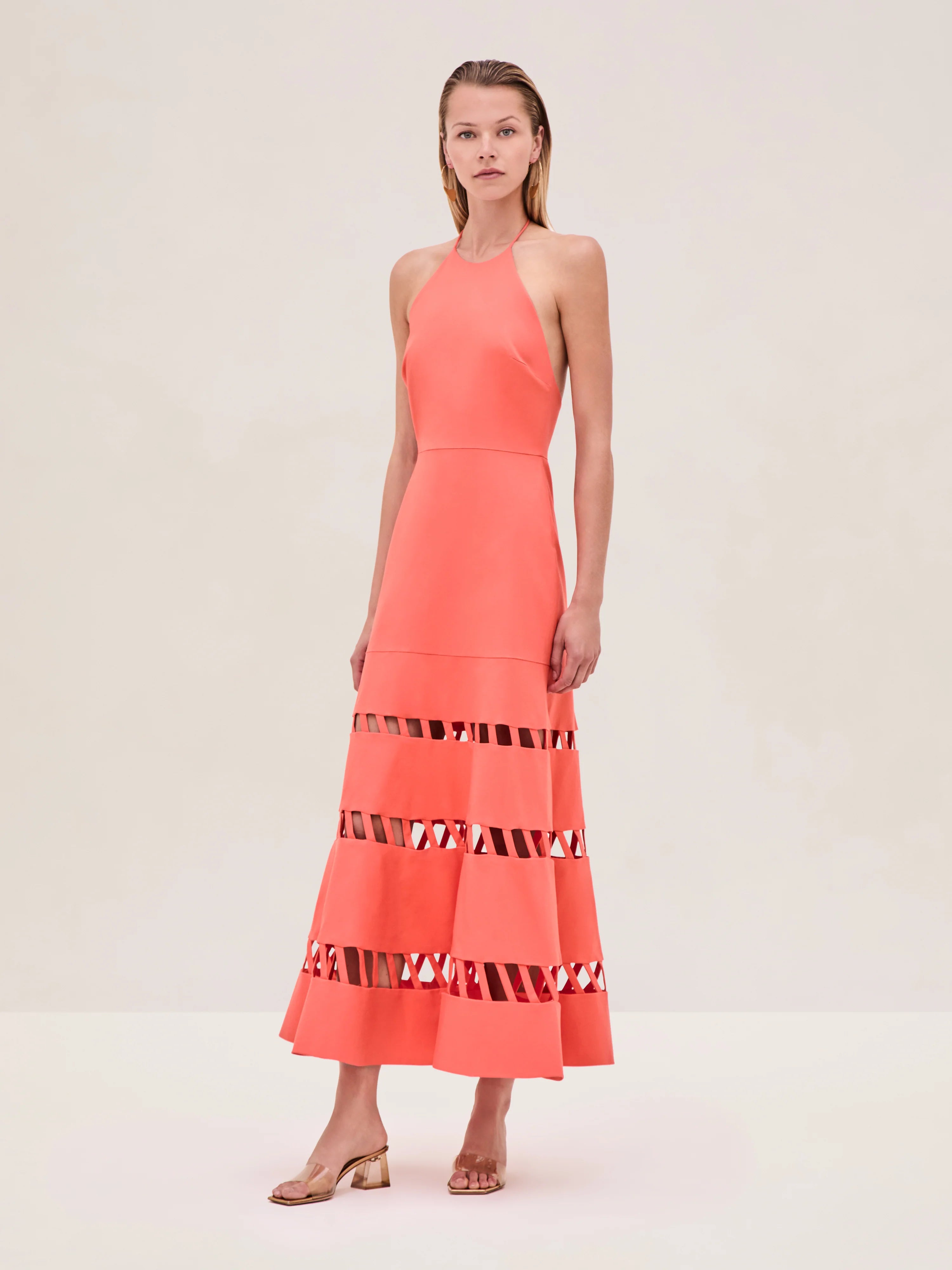The Janessa Dress by Alexis combines classic comfort with modern detail through its breathable cotton fabric and halter neckline. Its midi length offers versatile styling options, while the distinctive cut-out ladder detailing adds an elegant touch of texture and visual interest, making it a refined choice for warm-weather occasions.