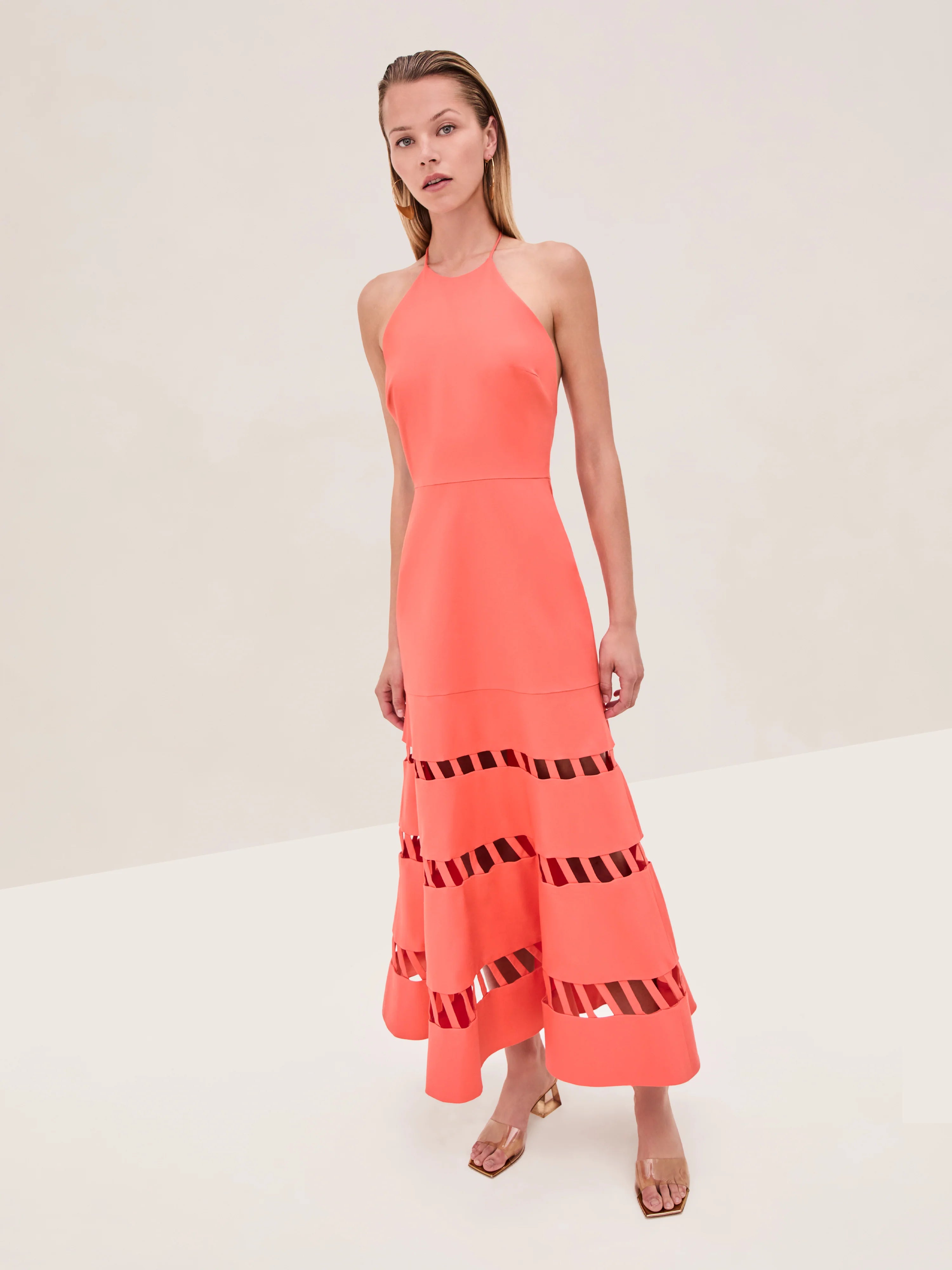 The Janessa Dress by Alexis combines classic comfort with modern detail through its breathable cotton fabric and halter neckline. Its midi length offers versatile styling options, while the distinctive cut-out ladder detailing adds an elegant touch of texture and visual interest, making it a refined choice for warm-weather occasions.