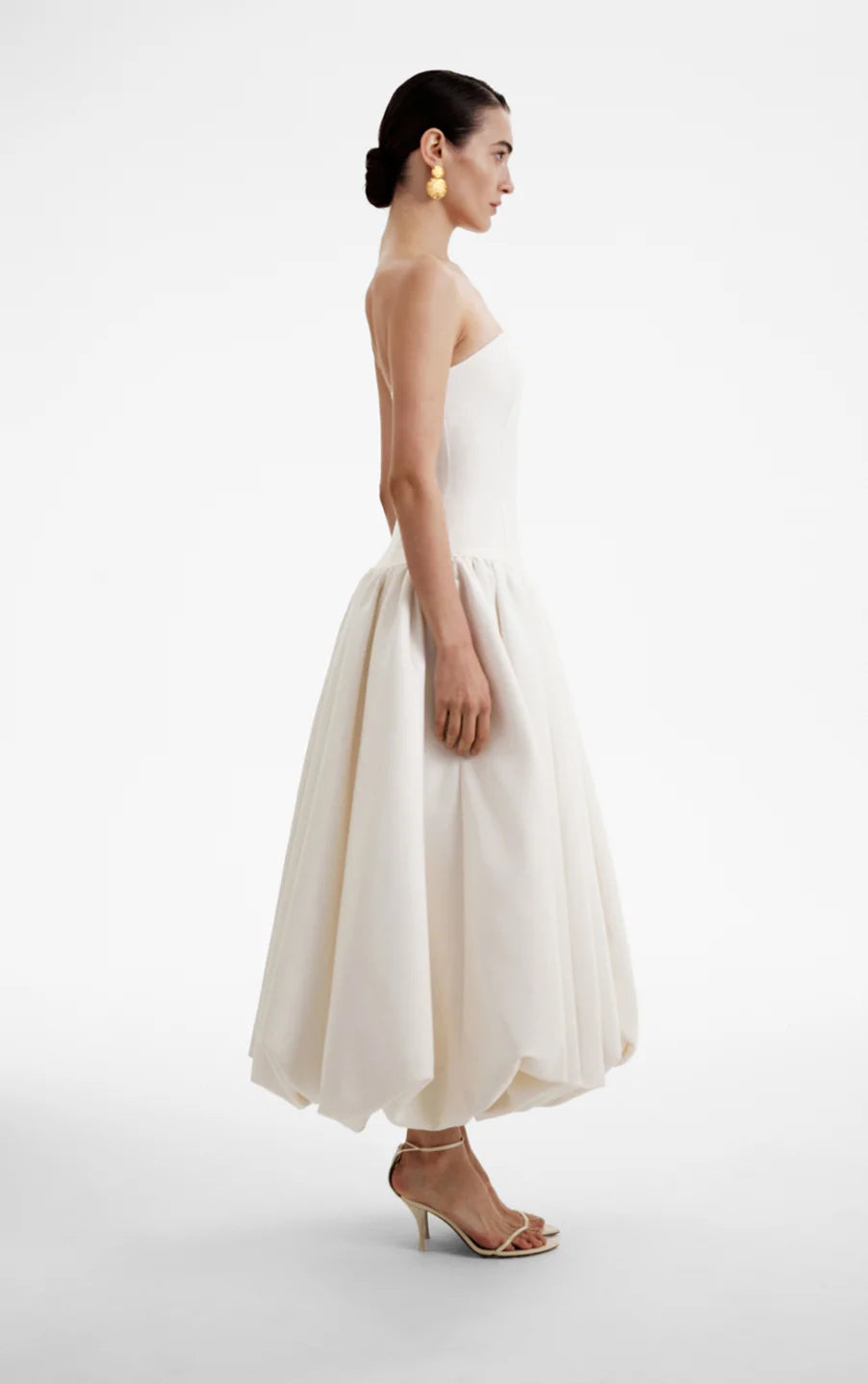 The Opera Gown combines classic elegance with contemporary design, featuring a strapless solid bodice and a high-waisted, pleated A-line skirt that flatters the figure. Its sleeveless construction offers both comfort and style, making it an excellent choice for summer occasions and formal events. This gown seamlessly blends sophistication with ease, providing a refined yet effortless look for warm-weather gatherings.