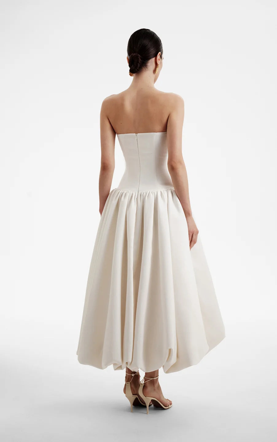 The Opera Gown combines classic elegance with contemporary design, featuring a strapless solid bodice and a high-waisted, pleated A-line skirt that flatters the figure. Its sleeveless construction offers both comfort and style, making it an excellent choice for summer occasions and formal events. This gown seamlessly blends sophistication with ease, providing a refined yet effortless look for warm-weather gatherings.
