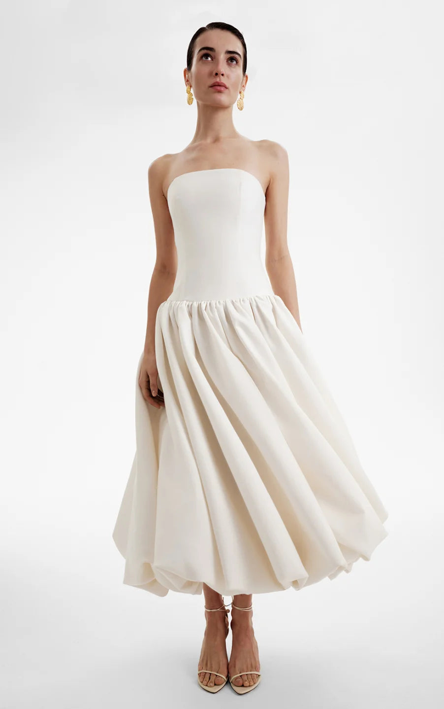 The Opera Gown combines classic elegance with contemporary design, featuring a strapless solid bodice and a high-waisted, pleated A-line skirt that flatters the figure. Its sleeveless construction offers both comfort and style, making it an excellent choice for summer occasions and formal events. This gown seamlessly blends sophistication with ease, providing a refined yet effortless look for warm-weather gatherings.