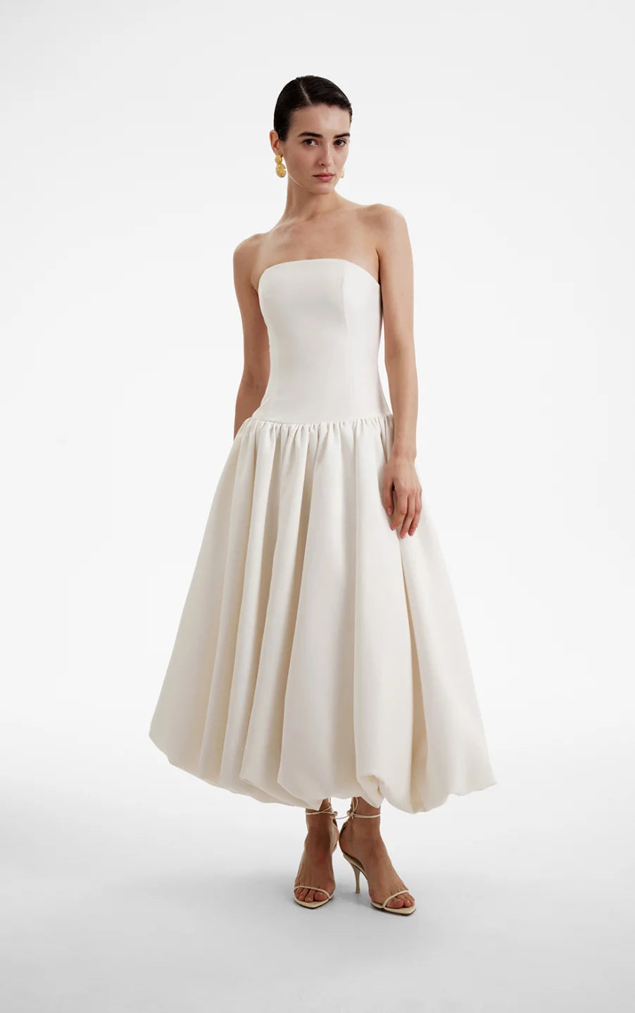 The Opera Gown combines classic elegance with contemporary design, featuring a strapless solid bodice and a high-waisted, pleated A-line skirt that flatters the figure. Its sleeveless construction offers both comfort and style, making it an excellent choice for summer occasions and formal events. This gown seamlessly blends sophistication with ease, providing a refined yet effortless look for warm-weather gatherings.