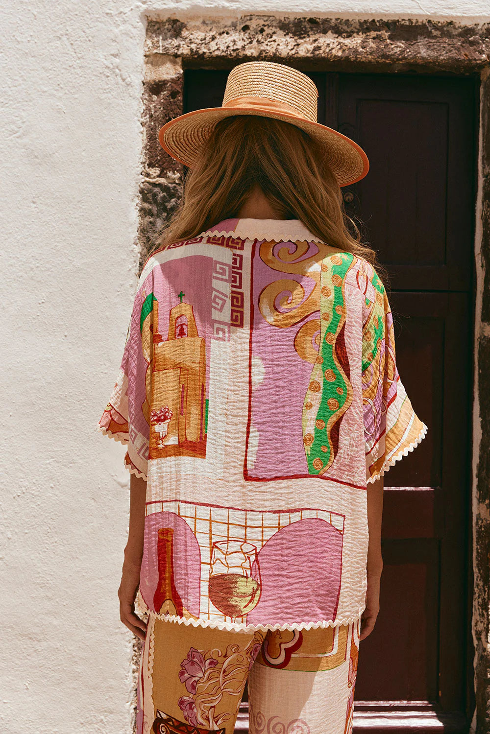 The Kelia Shirt in Theotokos Peach by Sabo is a boxy fit shirt featuring the exclusive Resort&nbsp; print. Made with a blend of viscose and nylon, this shirt offers a comfortable fit and stylish details such as a collar, low lapel, and ric rac trim. Perfect for adding a touch of unique elegance to your wardrobe.