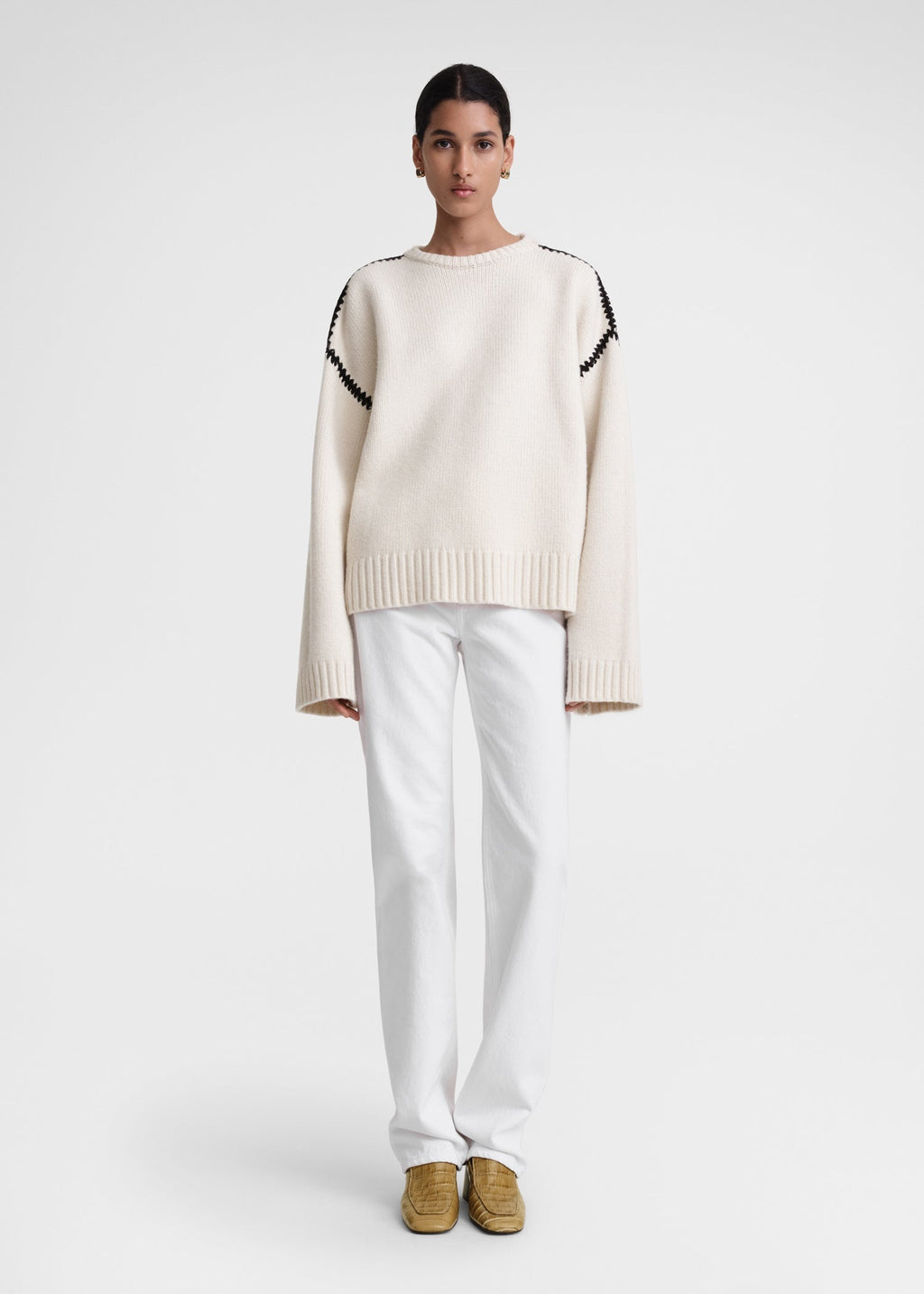 This wide sweater channels the refined aesthetic of TOTEME's Embroidered Scarf Jacket, crafted from mid-weight wool blended with cashmere for superior warmth and softness. Detailed with contrasting thread embroidery along the shoulders and armholes, it adds a sophisticated artisanal touch to classic knitwear. Pair it with the matching scarf to create a cohesive, statement winter ensemble that combines comfort with expert craftsmanship.