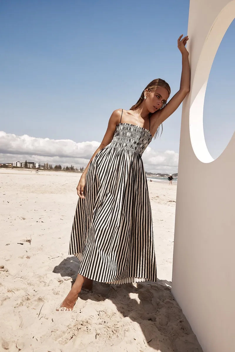 The Estelle Dress is a must-have for any wardrobe. The elegant Maxi Dress in Black and Beige Stripe offers a stylish addition with its straight neckline and adjustable shoulder straps. The elasticated shirred bodice ensures a comfortable fit while the side pockets add practicality. Enjoy effortless style and versatility with this lightweight, unlined dress.