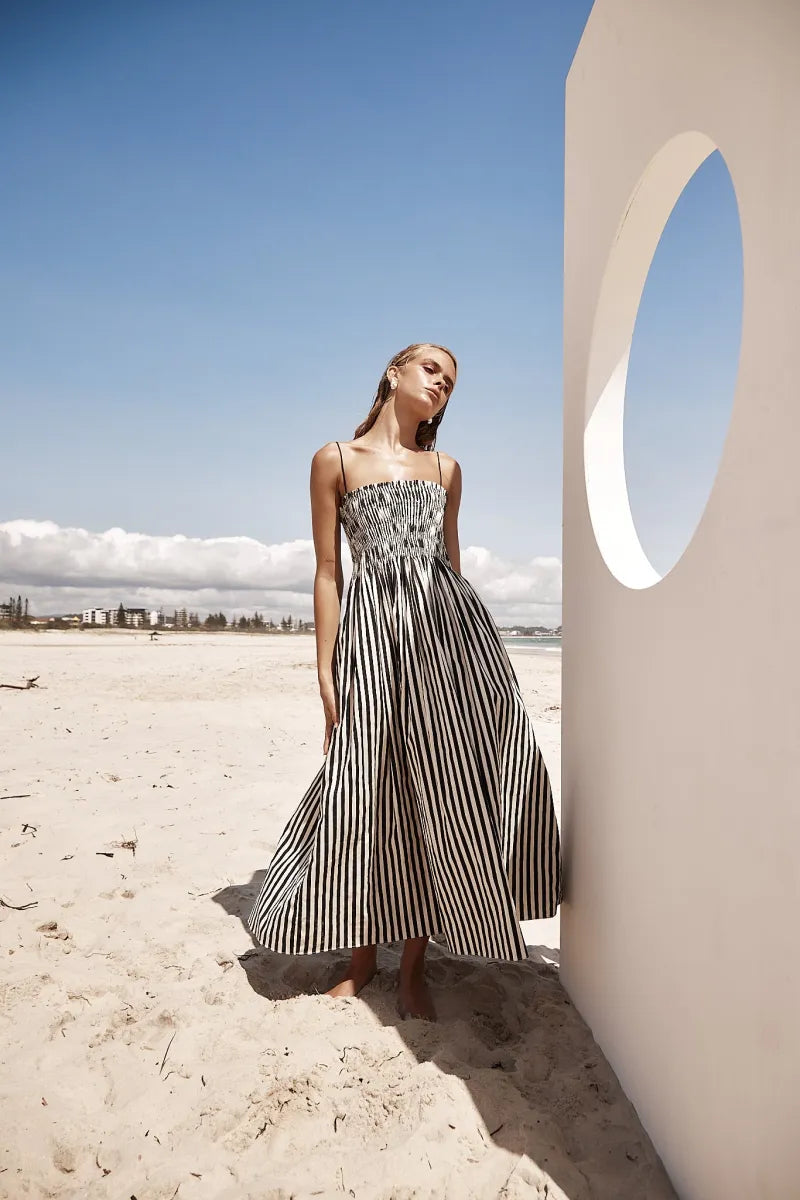 The Estelle Dress is a must-have for any wardrobe. The elegant Maxi Dress in Black and Beige Stripe offers a stylish addition with its straight neckline and adjustable shoulder straps. The elasticated shirred bodice ensures a comfortable fit while the side pockets add practicality. Enjoy effortless style and versatility with this lightweight, unlined dress.