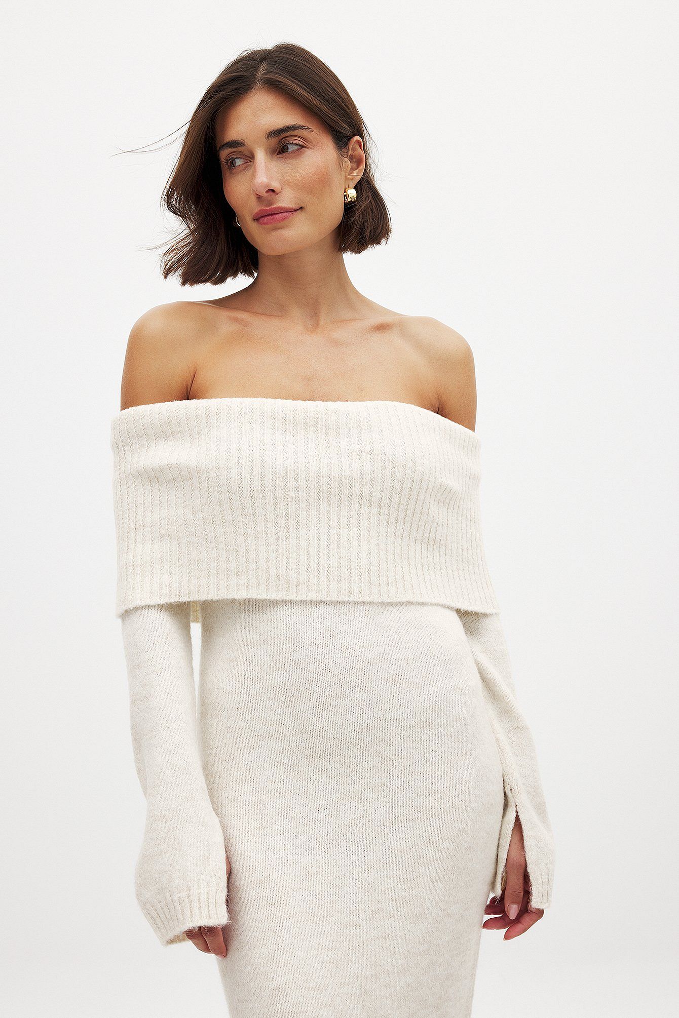 This knitted midi dress combines comfort and style with its relaxed fit and stretchy knit fabric, ensuring ease of movement throughout the day. The folded off-shoulder design adds a touch of elegance, while the long sleeves feature a subtle slit detail for an understated, modern edge. Ideal for sophisticated casual outings, this dress balances effortless wearability with refined fashion details.