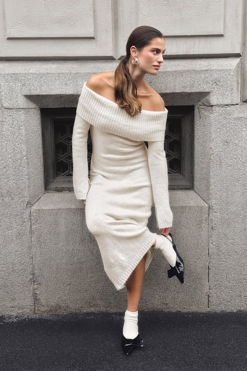 This knitted midi dress combines comfort and style with its relaxed fit and stretchy knit fabric, ensuring ease of movement throughout the day. The folded off-shoulder design adds a touch of elegance, while the long sleeves feature a subtle slit detail for an understated, modern edge. Ideal for sophisticated casual outings, this dress balances effortless wearability with refined fashion details.